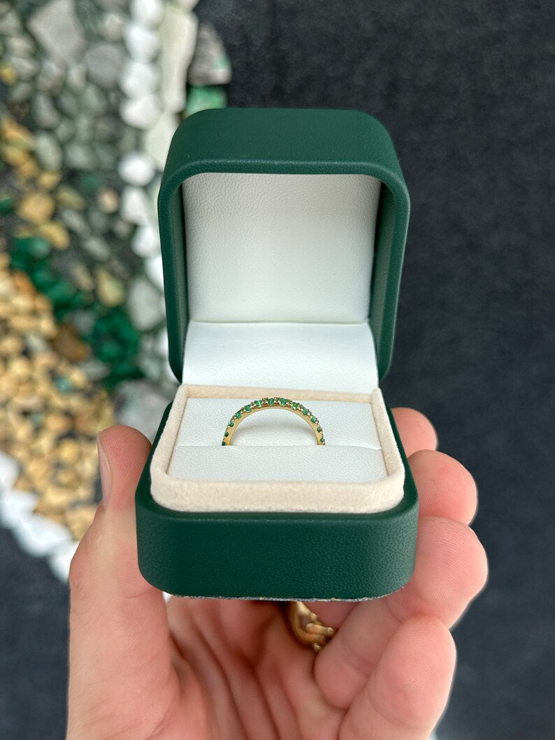 Medium dark green round cut emerald half eternity band ring in 14K gold, featuring 0.90tcw Colombian emeralds.