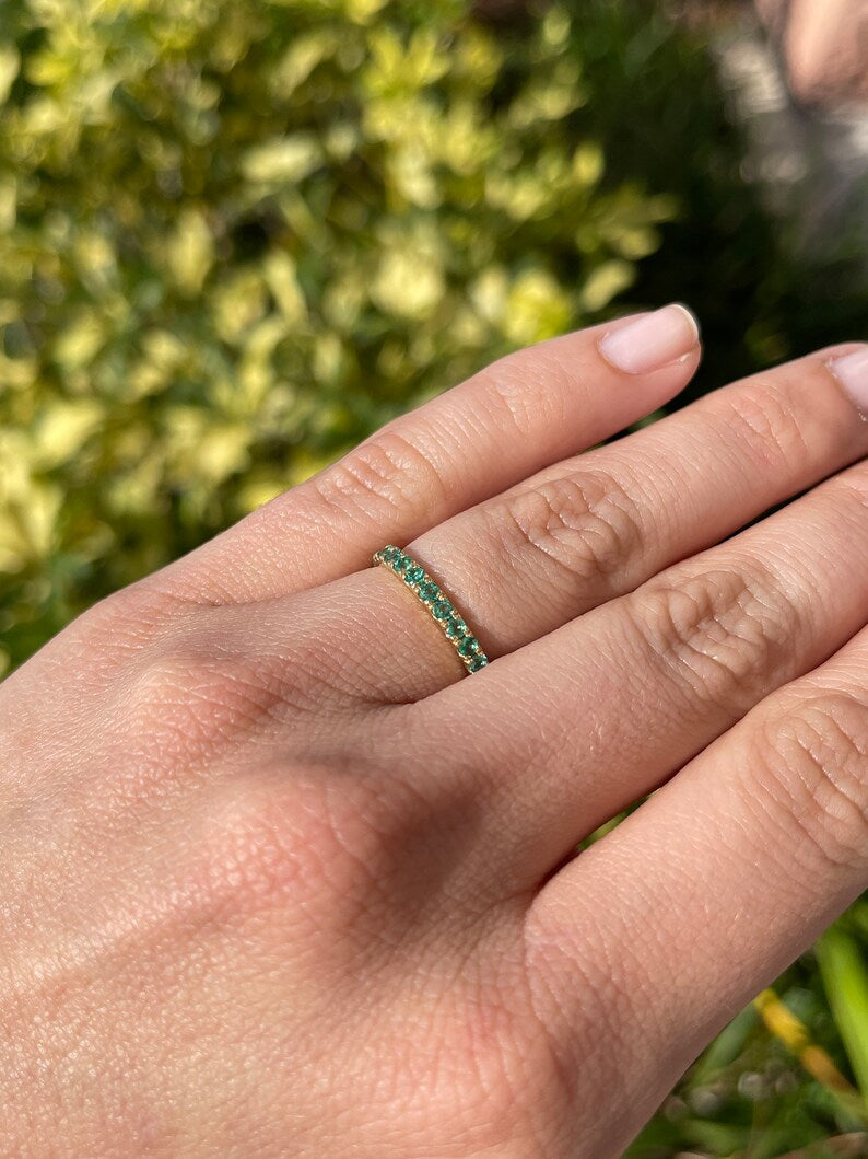 Medium dark green round cut emerald half eternity band ring in 14K gold with 0.90tcw Colombian emeralds.