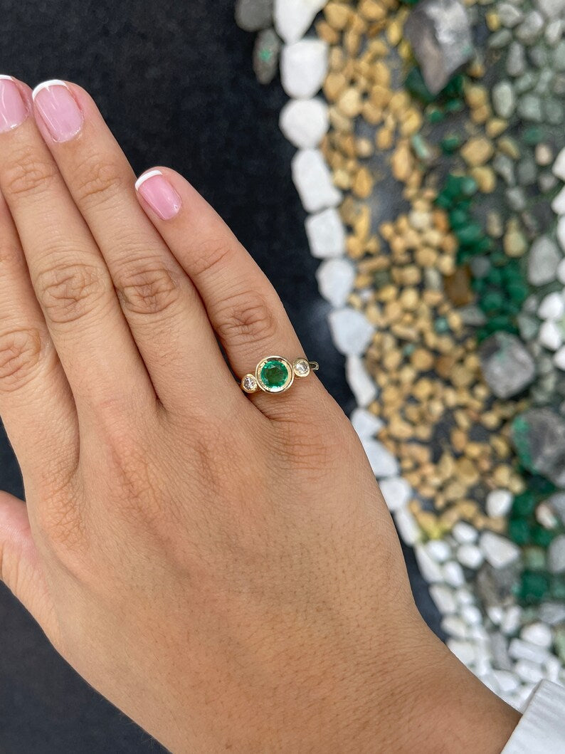 14K gold three stone engagement ring featuring round cut spring green emerald and diamonds by Colombian Emerald.