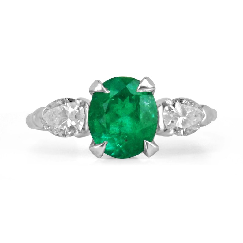 Colombian Emerald three-stone engagement ring with vivid dark green emeralds and diamond accents in fine jewelry style.