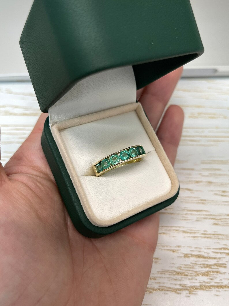 14K gold unisex engagement band ring with round cut emeralds, 2.30tcw, featuring a channel setting and 5.3mm width.
