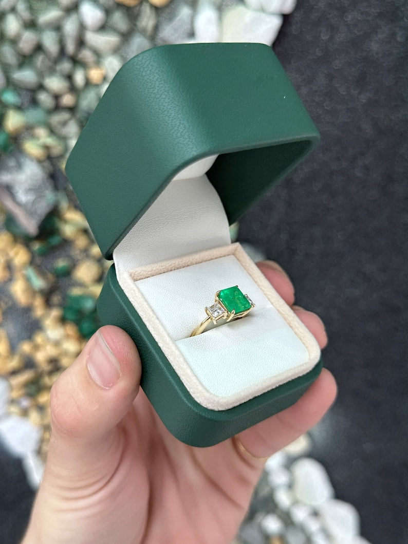 Colombian Emerald and princess cut diamond 3-stone ring in 14K gold, showcasing sparkling gemstones and elegant design.