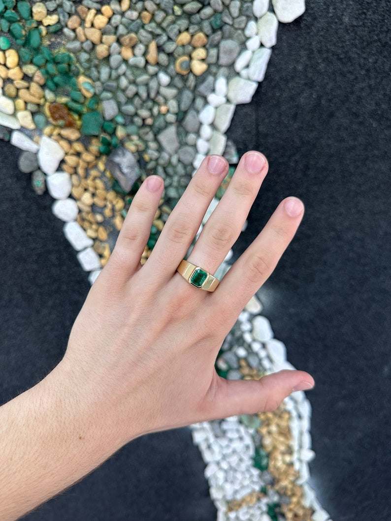Men's 14K gold ring featuring a 2.65ct dark green emerald cut Colombian emerald set north to south.
