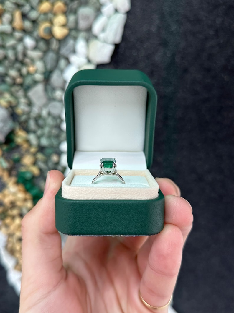 14K gold Colombian emerald solitaire ring with a 3.95ct lush dark green emerald cut gemstone and double claw prong setting.