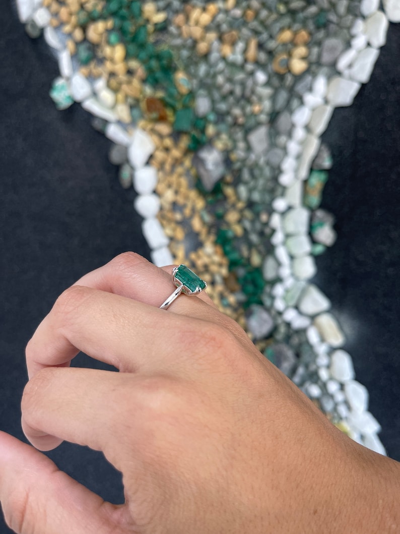 14K gold solitaire ring featuring a 3.95ct dark green emerald cut emerald with double claw prongs, from Colombian Emerald.