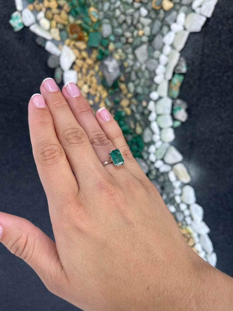 14K gold emerald cut dark green emerald solitaire ring with double claw prongs, Colombian Emerald brand, showcasing elegant jewelry design