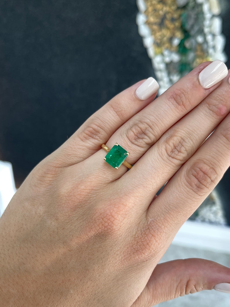 18K gold emerald solitaire engagement ring featuring a 3.95ct rich green Colombian emerald with four prongs on a sleek ring band