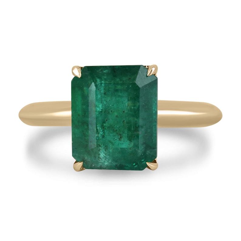 14K gold emerald cut solitaire engagement ring with rich green Colombian emerald, 4-prong setting, showcasing elegance and craftsmanship.