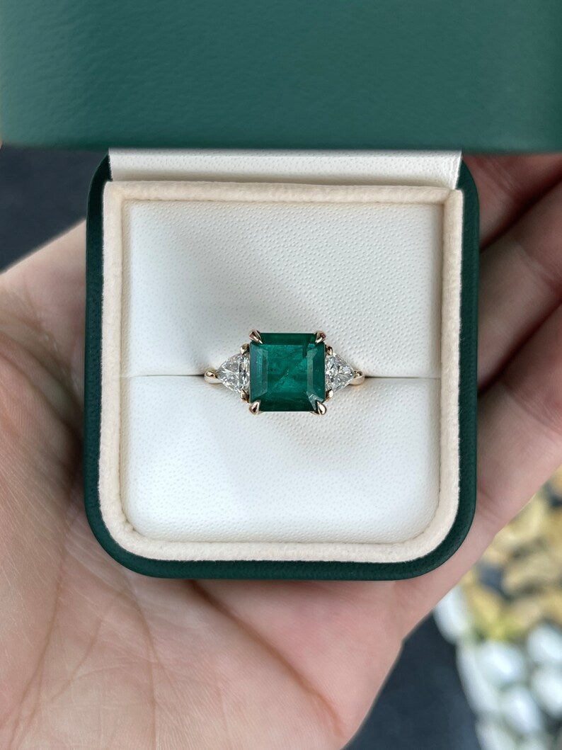 14K gold Colombian Emerald engagement ring with trillion and Asscher cut emeralds and diamonds, featuring a three-stone design.