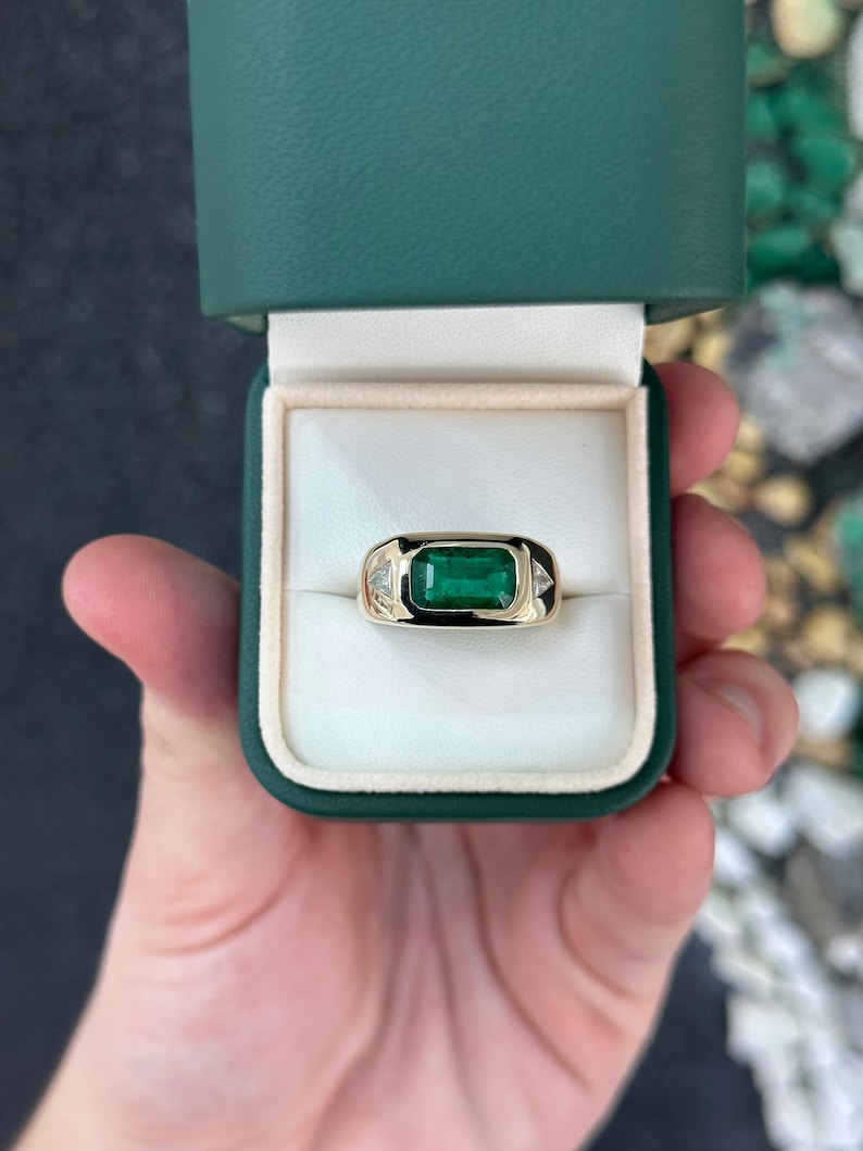 14K gold chunky east-to-west emerald and diamond triangle ring with rich forest green emeralds and sparkling diamonds.