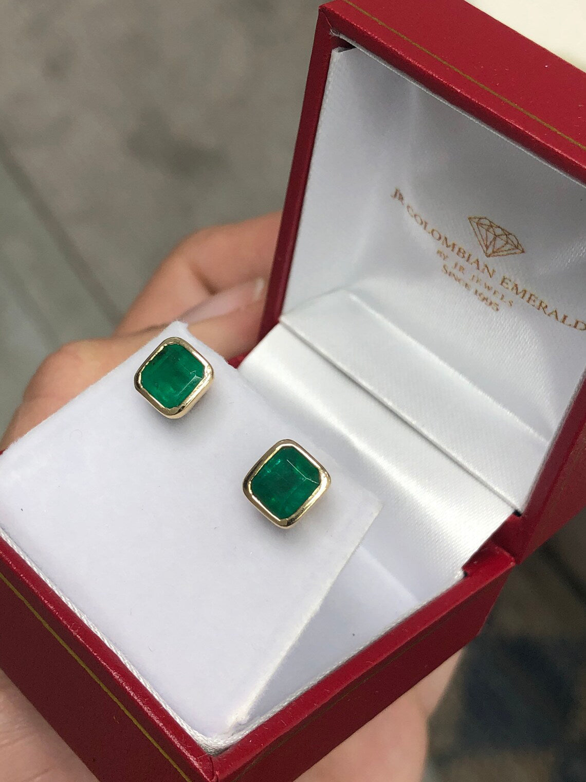2.20tcw Asscher cut natural emerald dark green bezel set earrings in 14K yellow gold box.