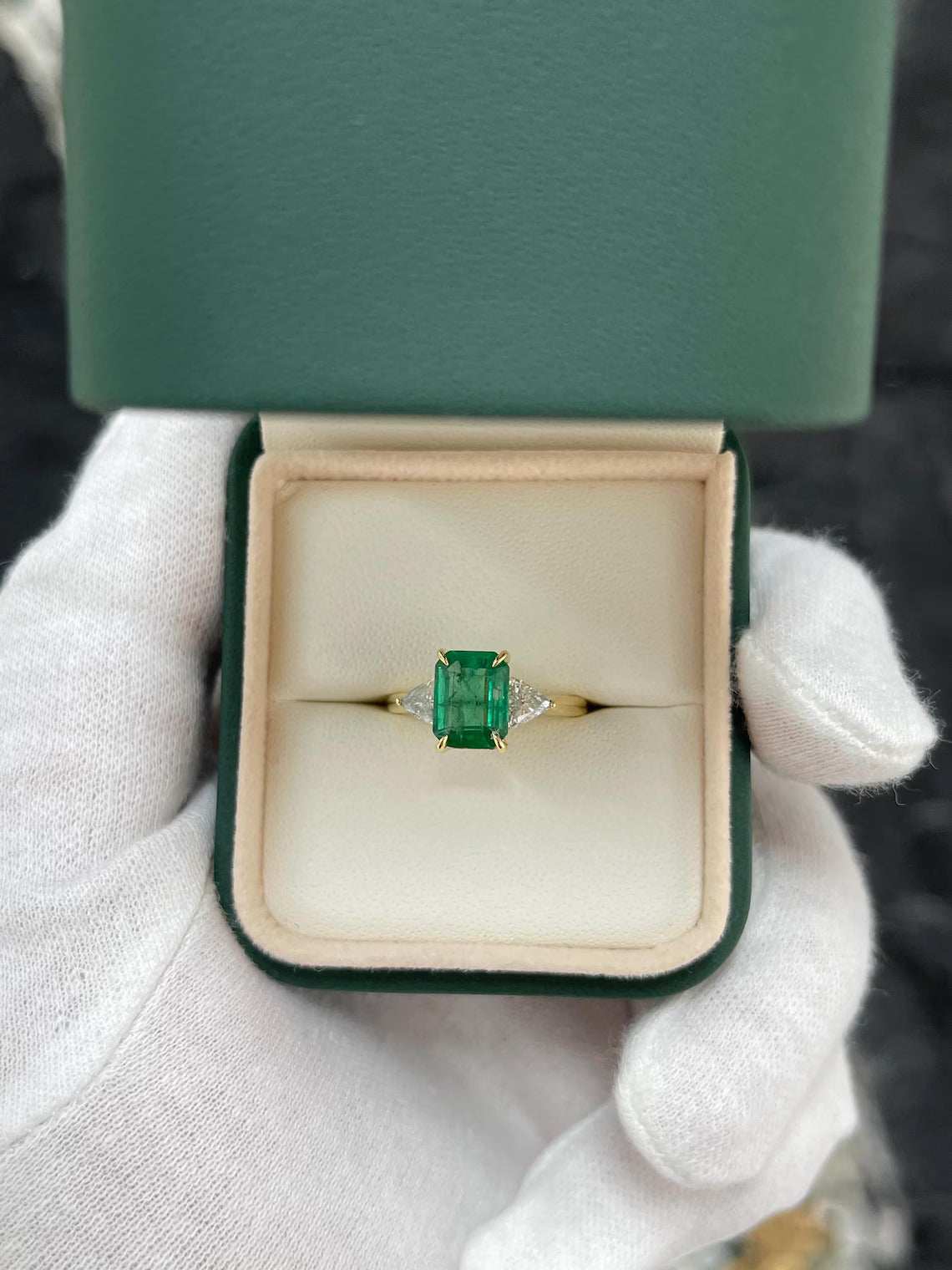 2.37 Carat Emerald Cut Emerald Features Trillion Diamond Side Stones