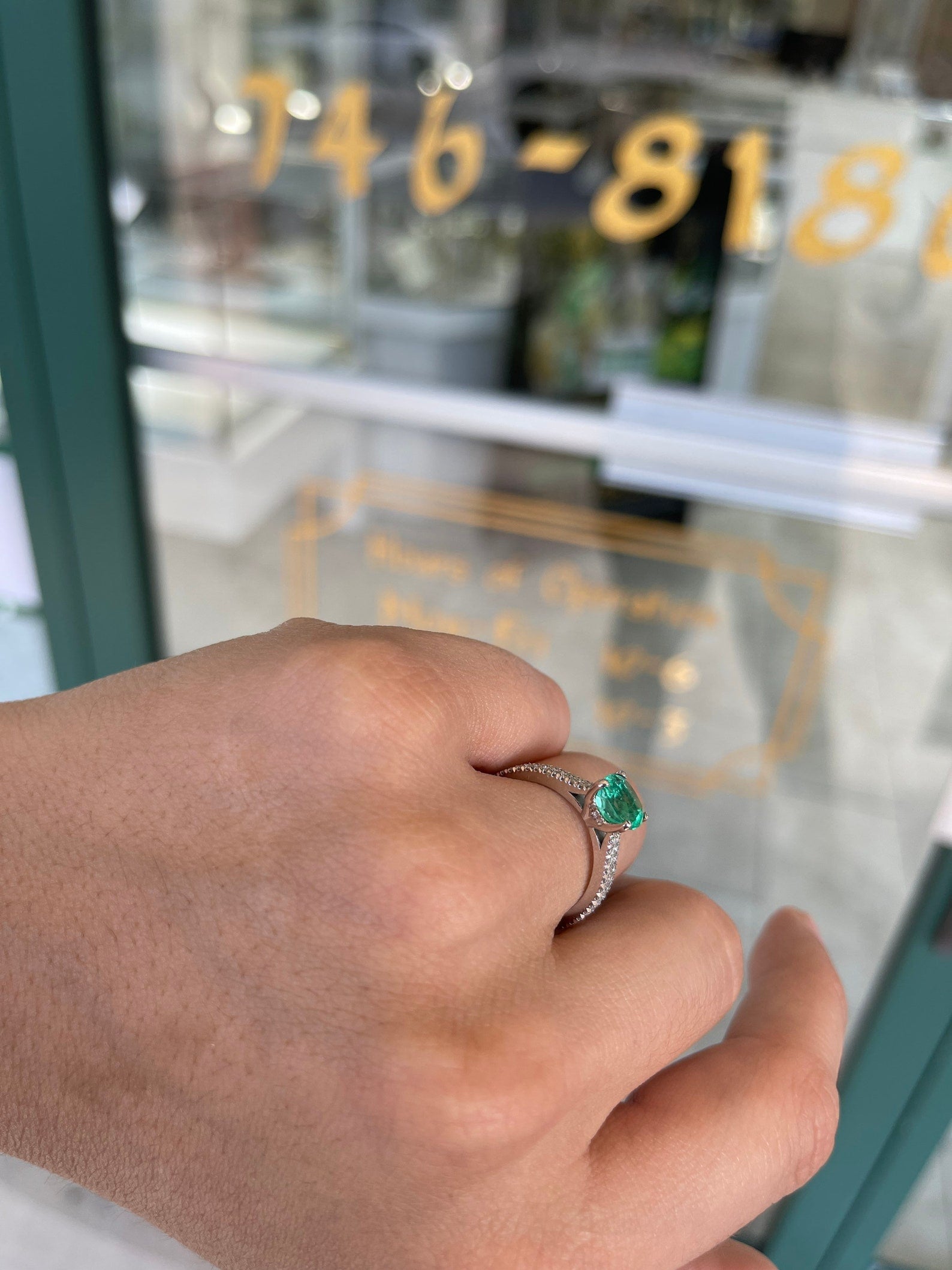 Colombian emerald cushion cut engagement ring with diamond accents in 14K gold, featuring prong setting and intricate detailing.