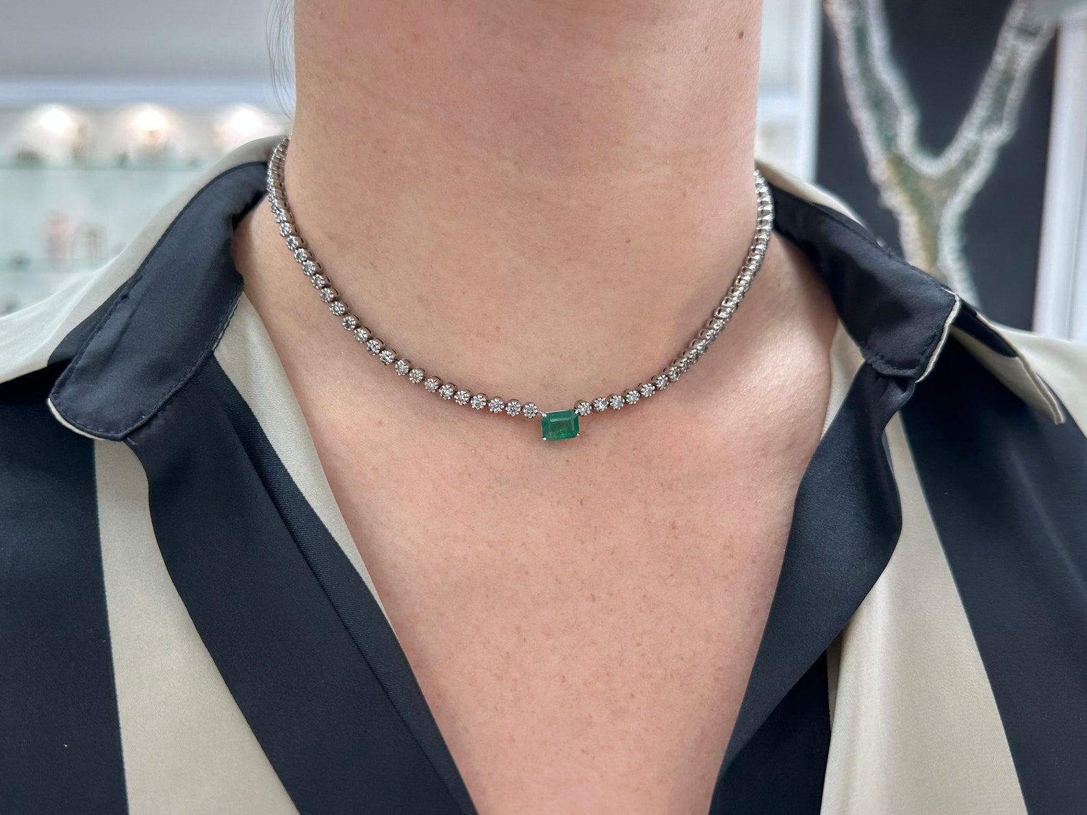 Emerald diamond tennis choker with 5.11-carat emeralds and diamonds in 14K white gold, featuring an eight-prong design.