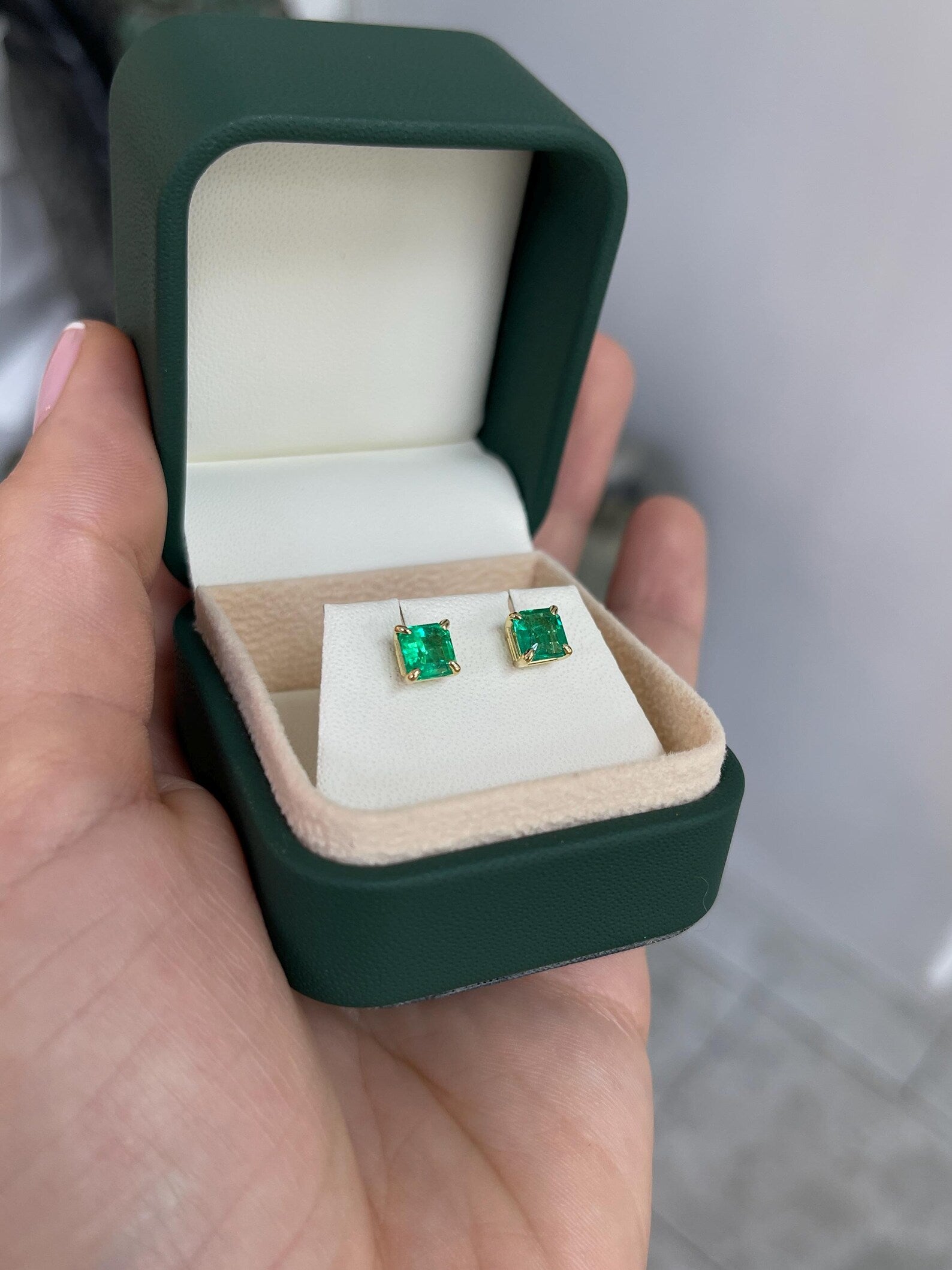 Green Asscher cut Colombian emerald stud earrings with four-prong settings by JR Colombian Emeralds, showcasing vibrant gemstone sparkle.