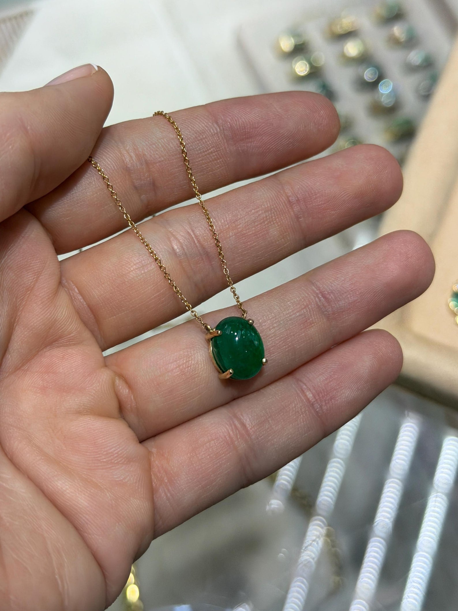 Zambian emerald cabochon pendant on 14K gold chain from JR Colombian Emeralds, showcasing a luxurious green gemstone.