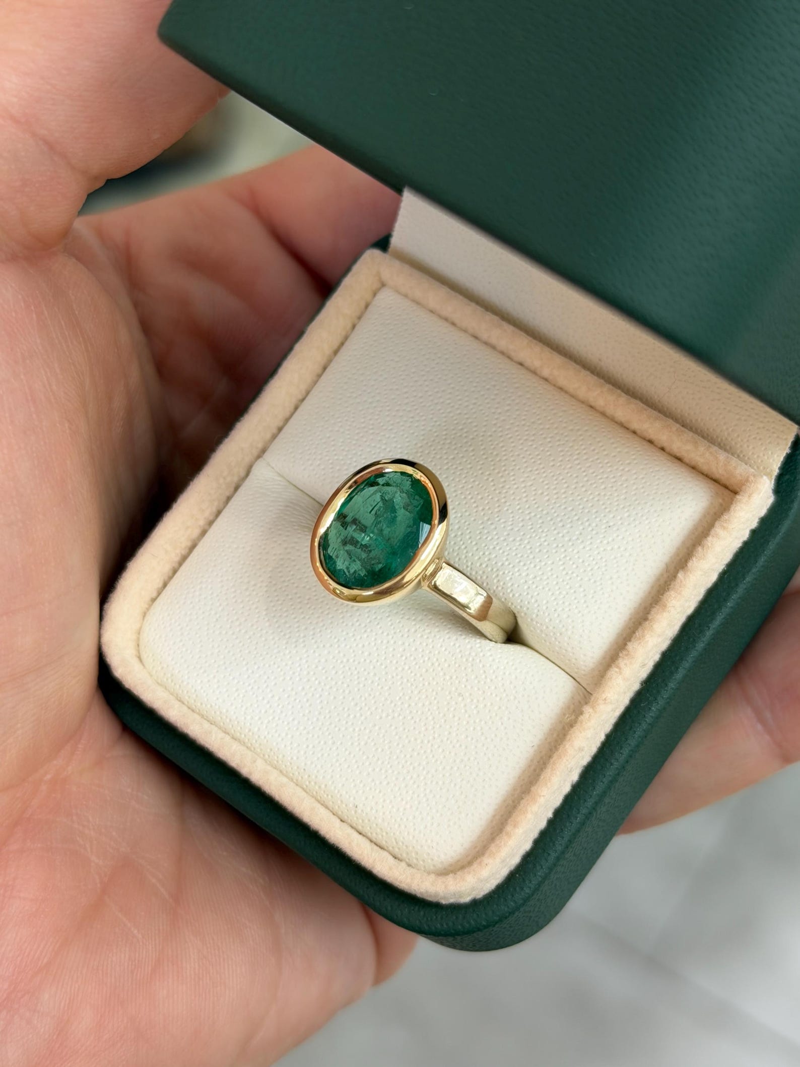 Elegant 3.85 carat oval cut emerald solitaire engagement ring with two-toned bezel in 585 gold by JR Colombian Emeralds.