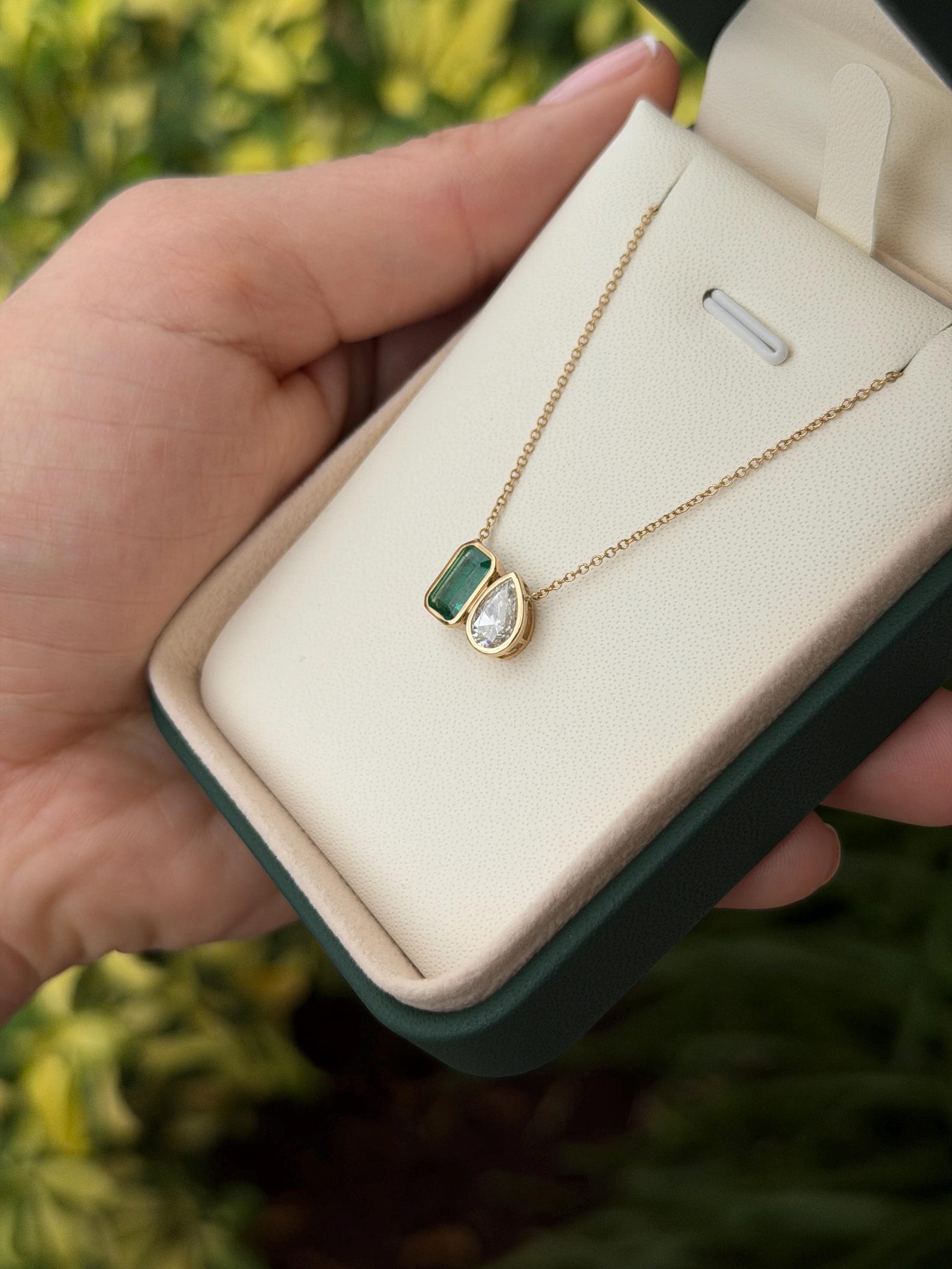 Emerald Moissanite Toi Et Moi pendant necklace with 14K gold chain, featuring two emerald-shaped gemstones for elegant jewelry.