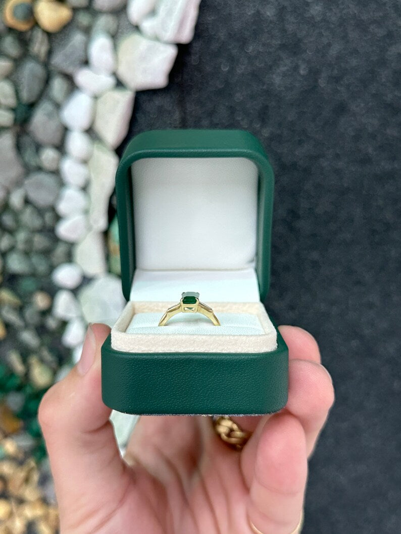 14K gold 2.45tcw dark green emerald and diamond accented 3-stone engagement ring featuring tapered baguette diamonds.