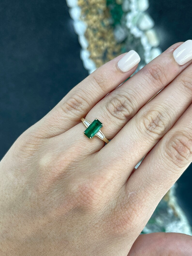 14K gold 2.45tcw emerald and diamond engagement ring featuring dark green emeralds and tapered baguette diamond accents.