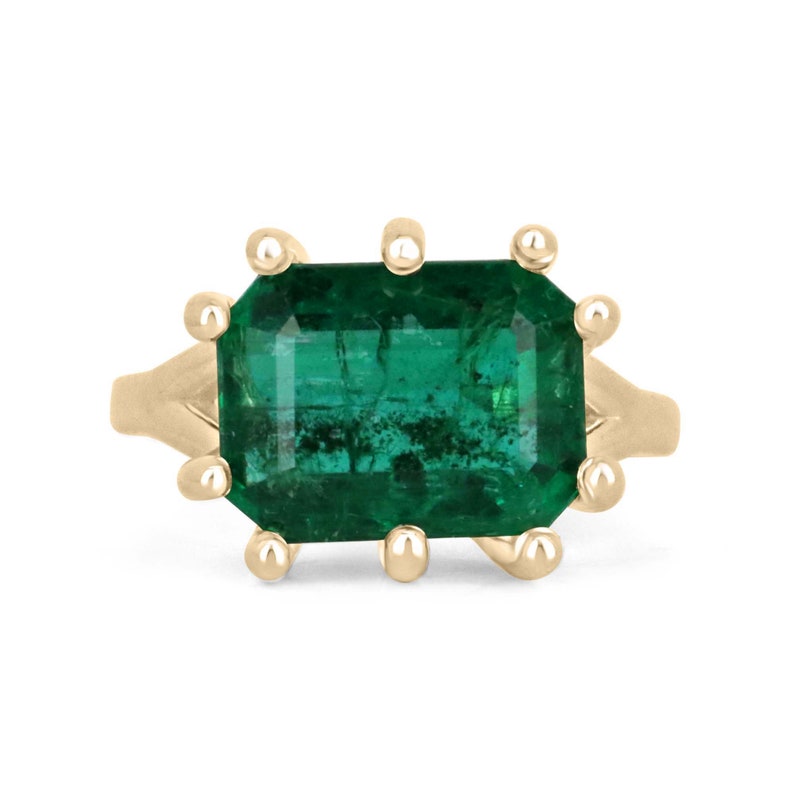 6.12ct emerald cut emerald solitaire ring in 18K yellow gold with 10-prong setting and deep rich green stone