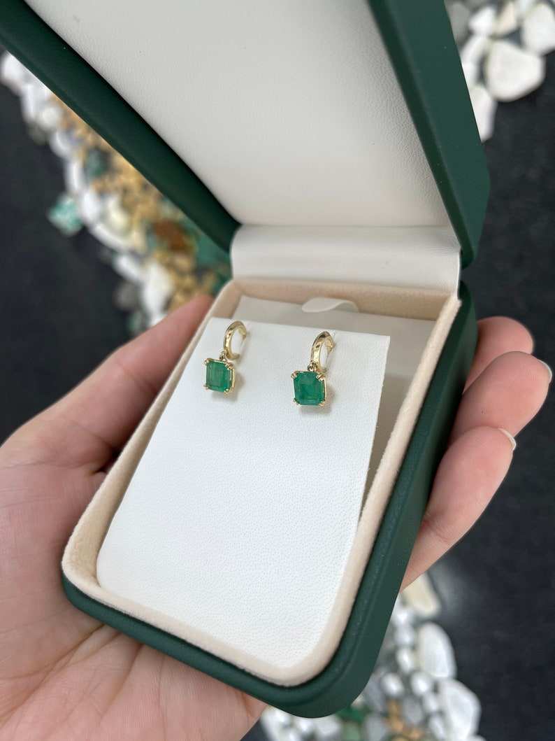 Natural emerald Asscher cut knife-edge huggie dangle earrings in 14K gold featuring 2.80tcw Colombian emeralds.