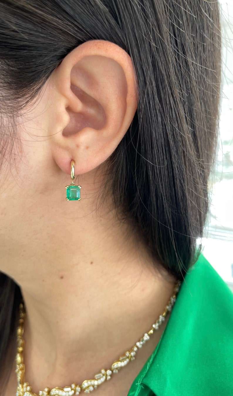 Natural emerald Asscher cut knife-edge huggie dangle earrings in 14K gold by Colombian Emerald, featuring 2.80 tcw of vibrant green gemstones.