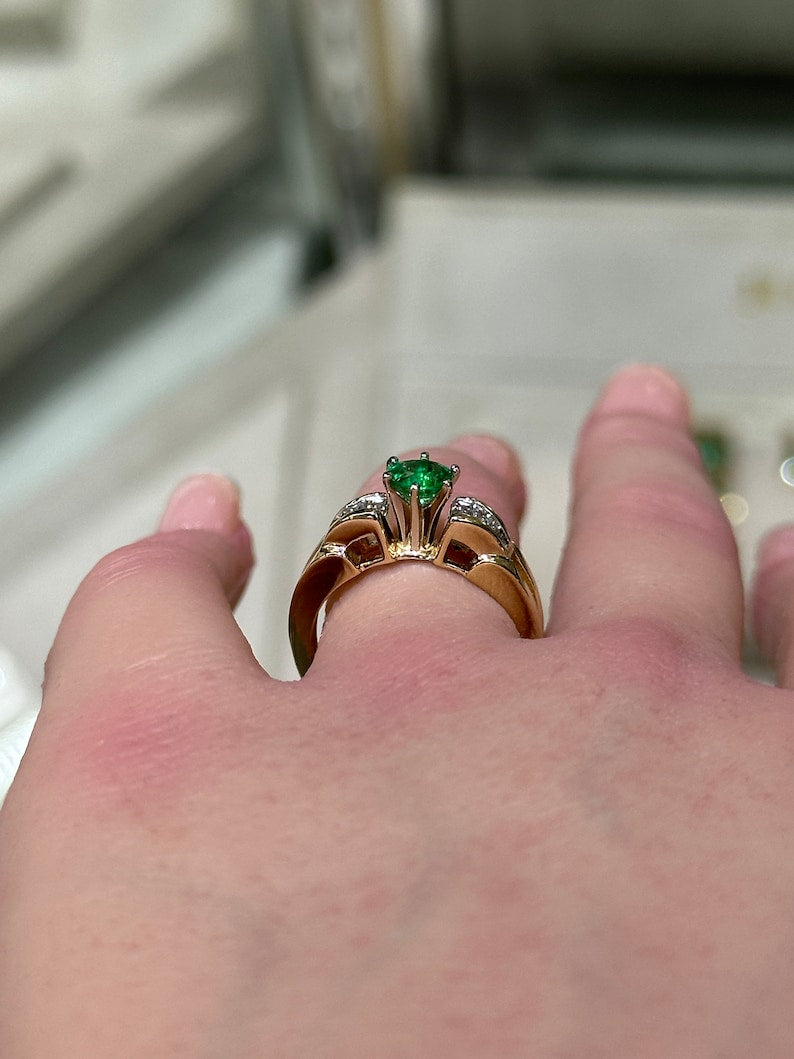 14K gold engagement ring with a 1.25 carat Colombian emerald center stone and diamond baguette accents in a 6-prong setting.