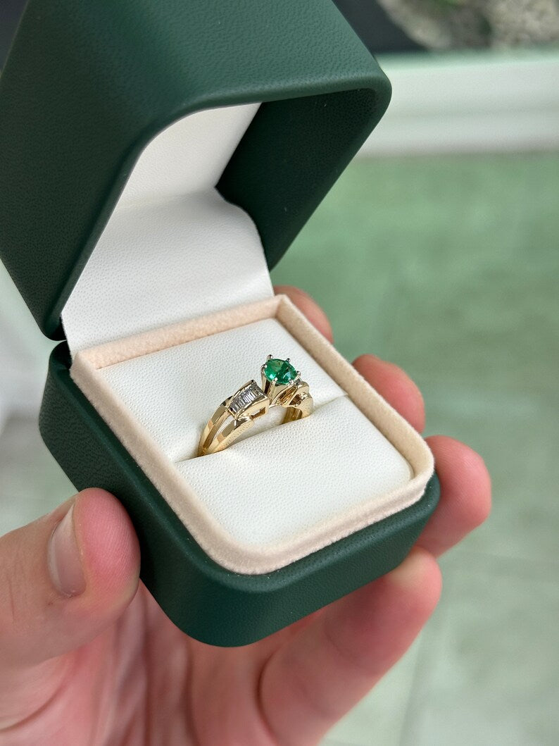 14K gold engagement ring with 1.25tcw round Colombian emerald center stone and diamond baguette accents in a six-prong setting.
