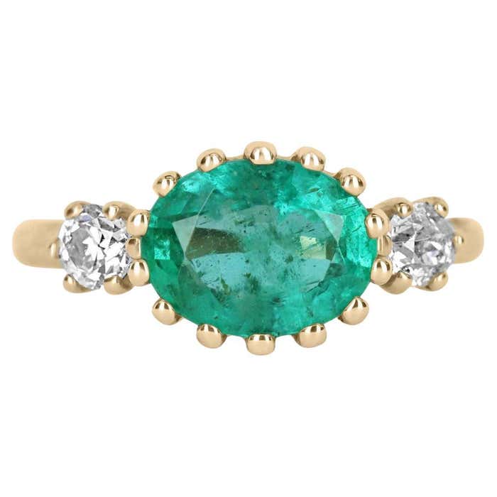 JR Colombian Emeralds 2.60 carat oval emerald and diamond three-stone solitaire ring in 14K gold with green accents.