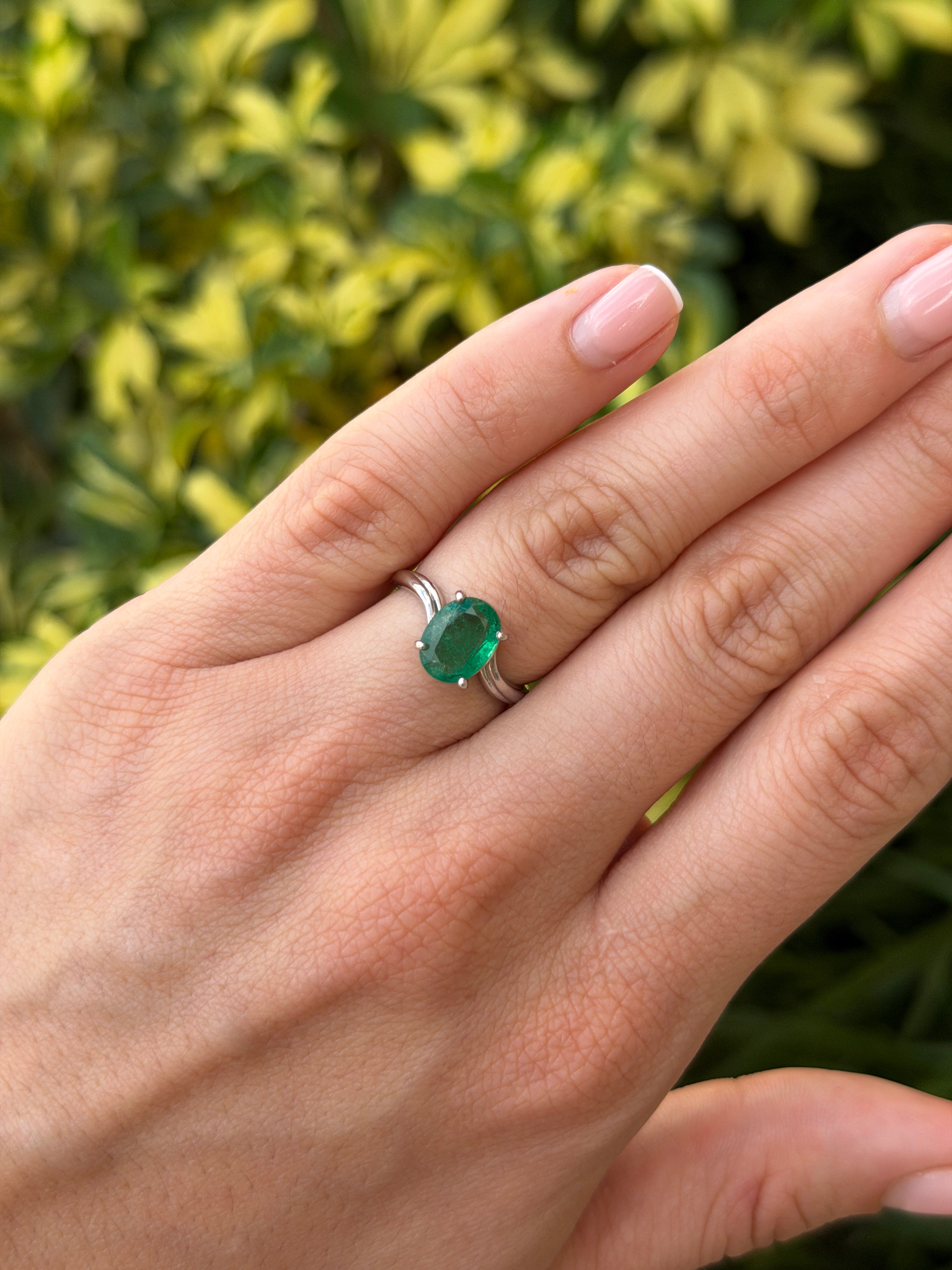 Natural 2.05ct oval emerald solitaire wave ring in 14K white gold, showcasing a vibrant green emerald gemstone.