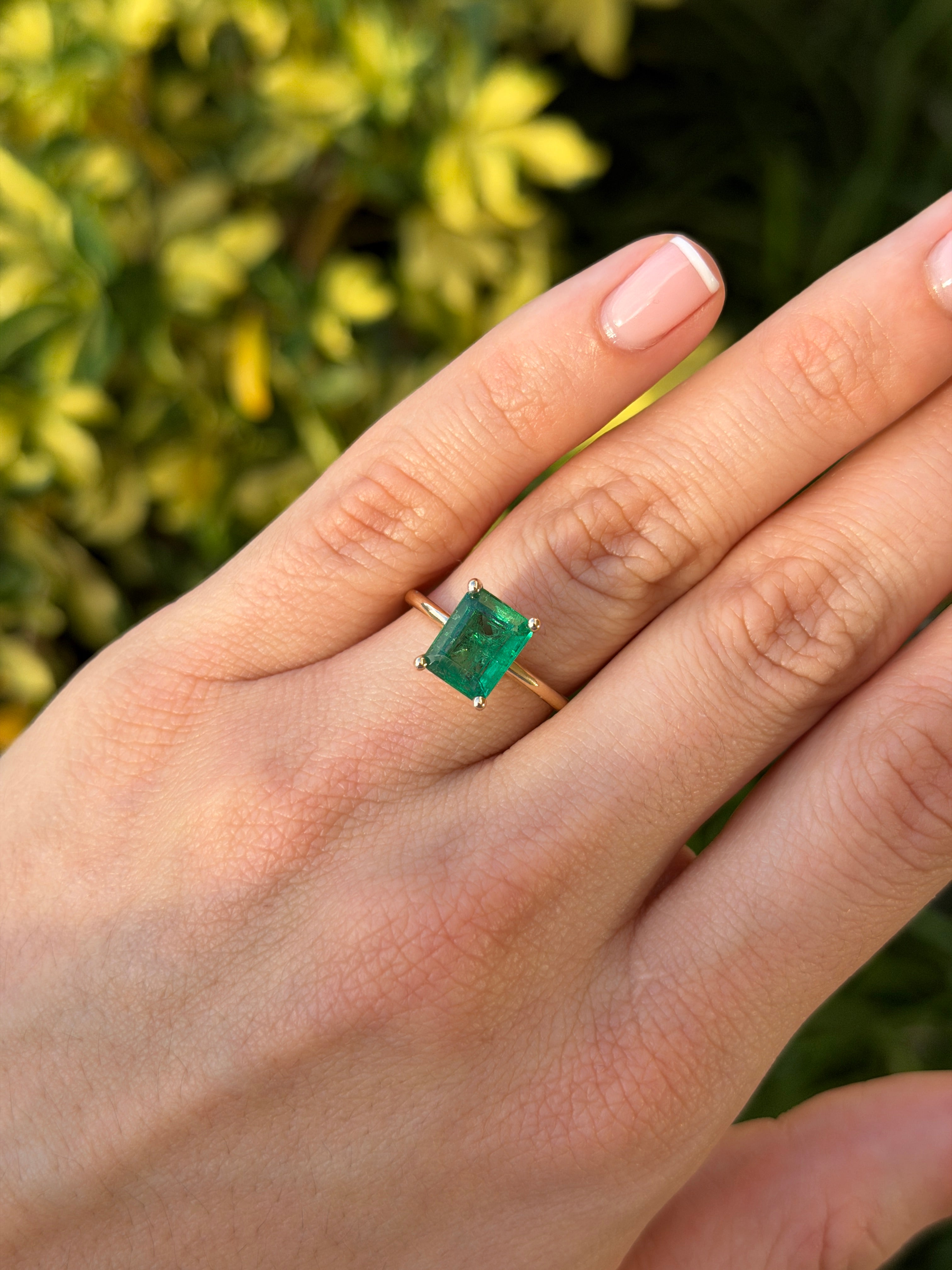 14K gold emerald solitaire ring featuring a 2.32 carat natural green emerald in a classic four-prong setting.