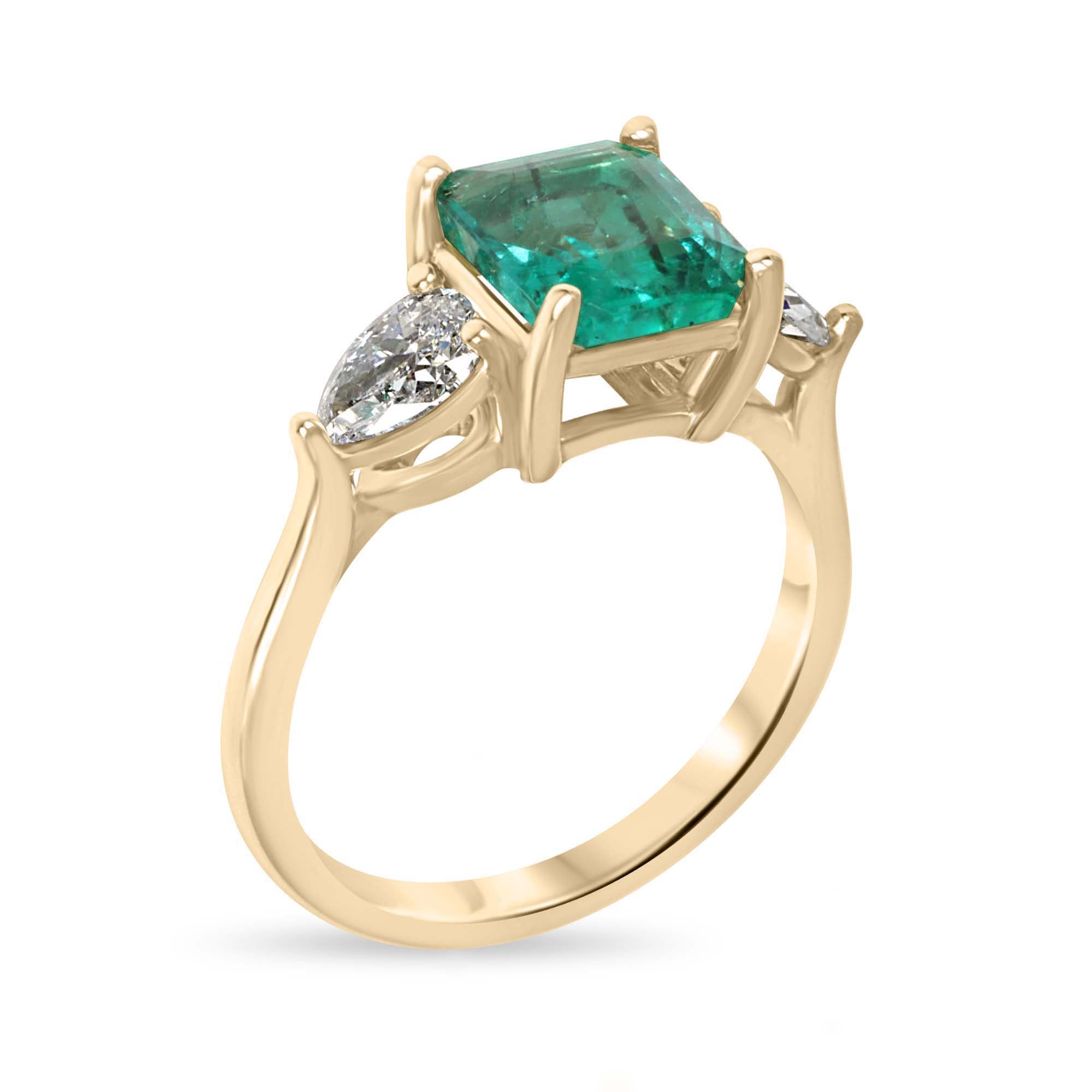 14K gold three-stone engagement ring featuring a natural freckled emerald and lab-grown pear-shaped diamonds by JR Colombian Emeralds.