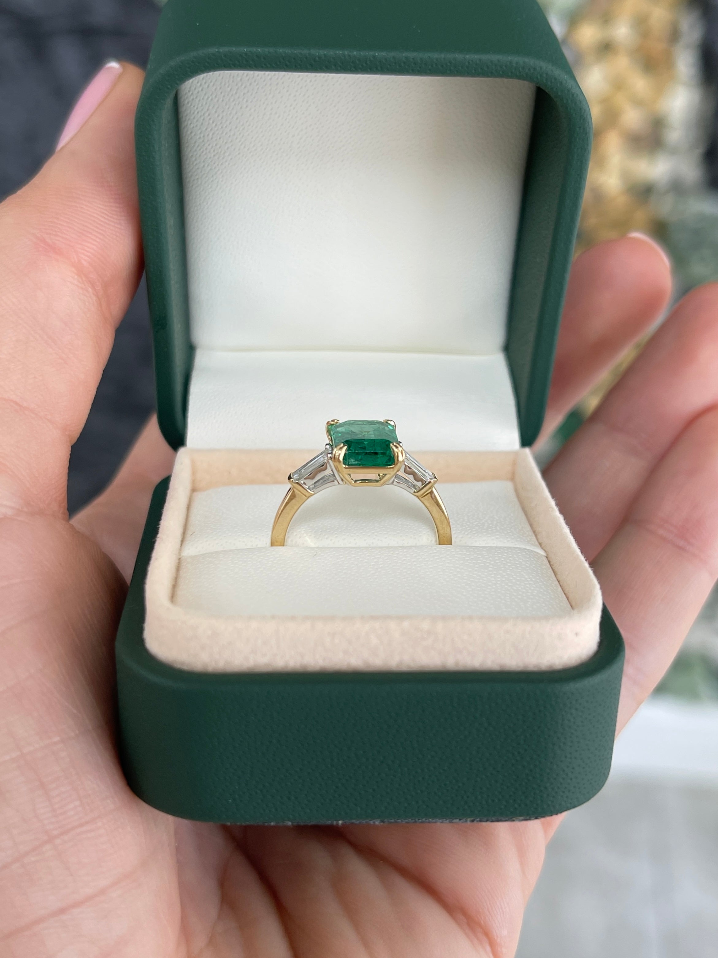 Two-toned 14K emerald cut emerald and baguette diamond three-stone engagement ring by JR Colombian Emeralds, featuring natural gemstones.