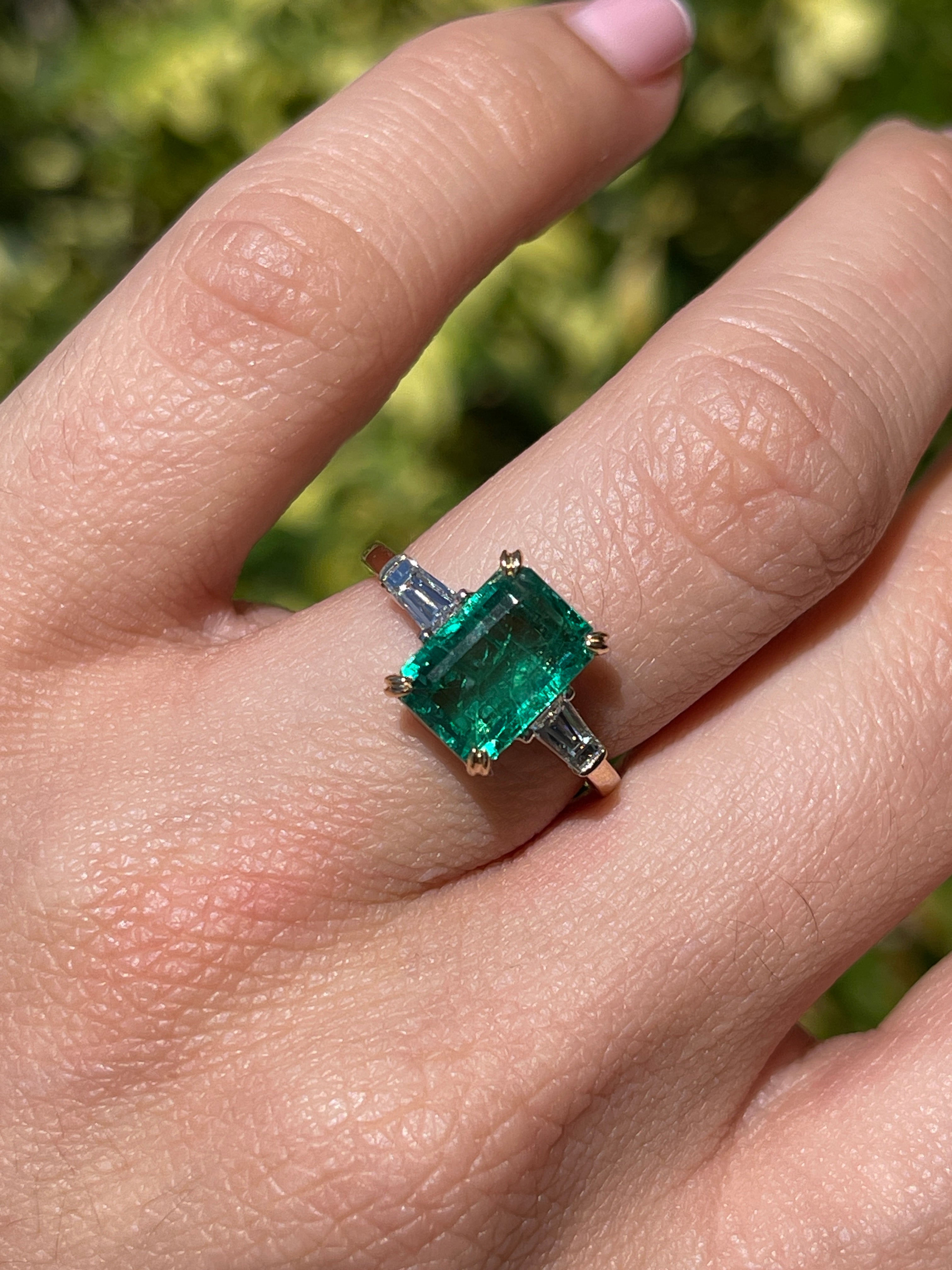 14K two-tone emerald cut emerald and baguette diamond three-stone engagement ring by JR Colombian Emeralds featuring natural gemstones.