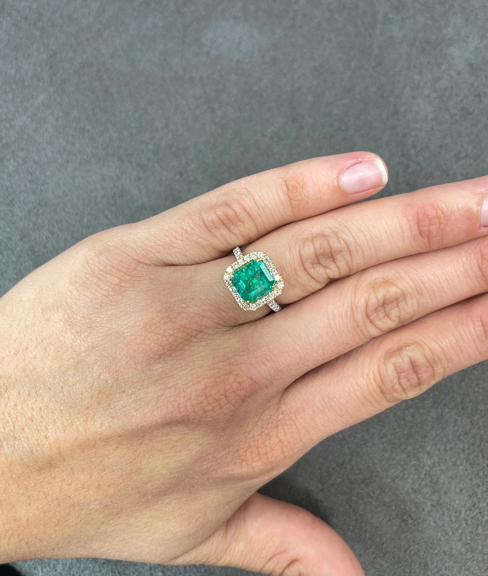 Asscher cut Colombian emerald and diamond halo ring in two-tone 18K gold by JR Colombian Emeralds, showcasing vibrant green gemstone.