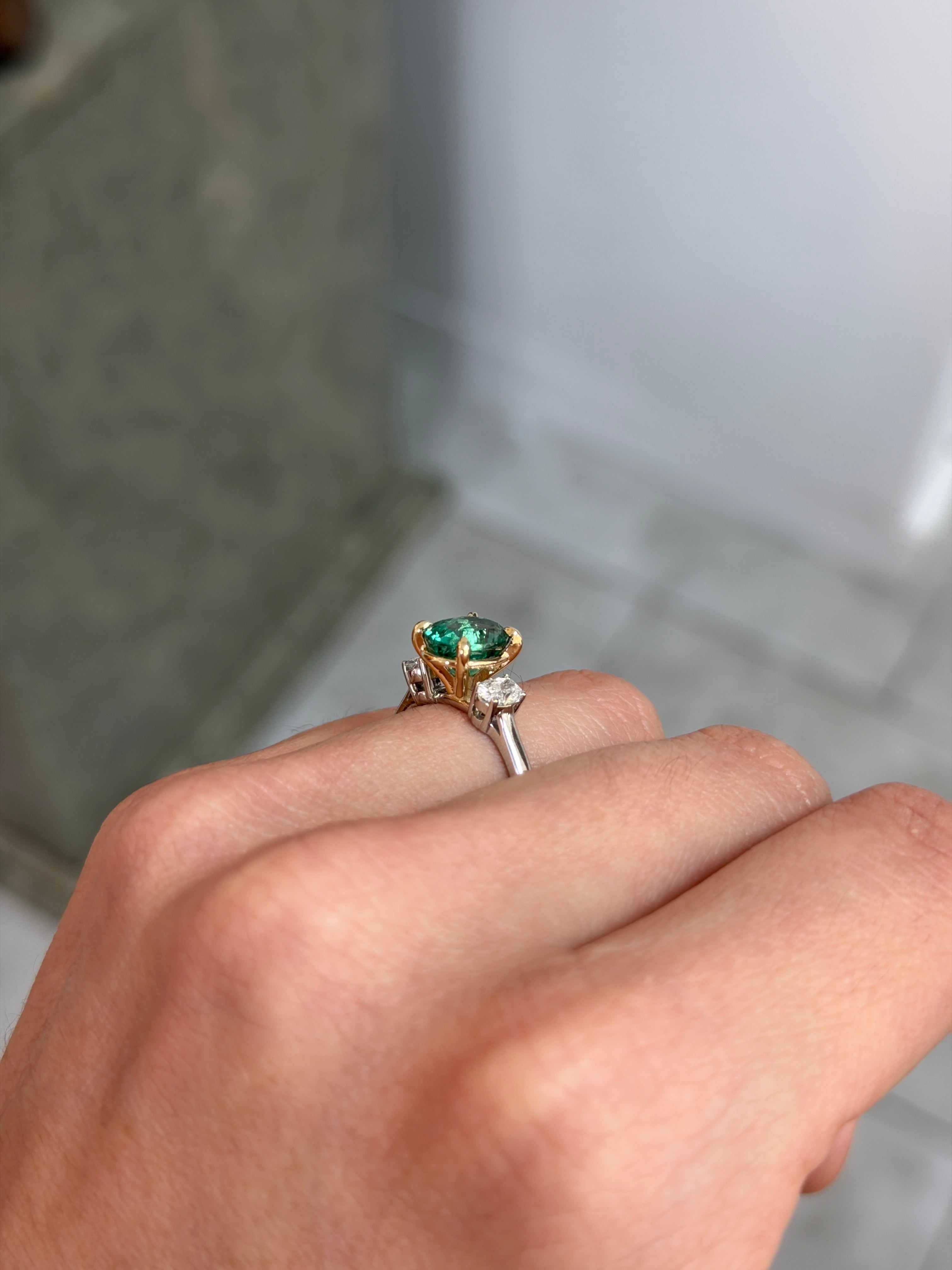 JR Colombian Emeralds 14K gold three stone engagement ring featuring 2.19tcw vibrant oval emerald and lab diamond accents.