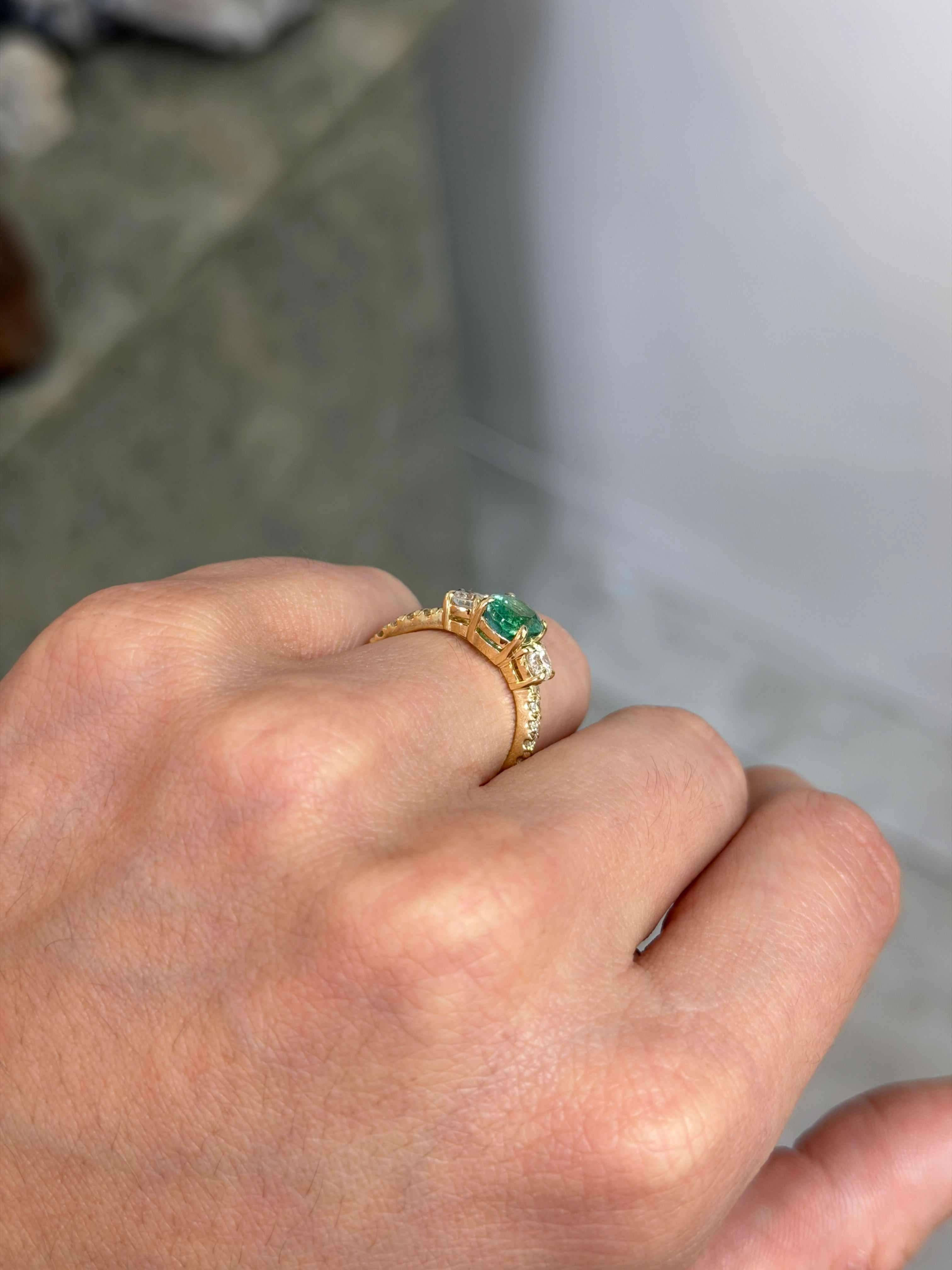 Oval emerald and round lab diamond three-stone ring with accent diamonds in 14K gold, by JR Colombian Emeralds.