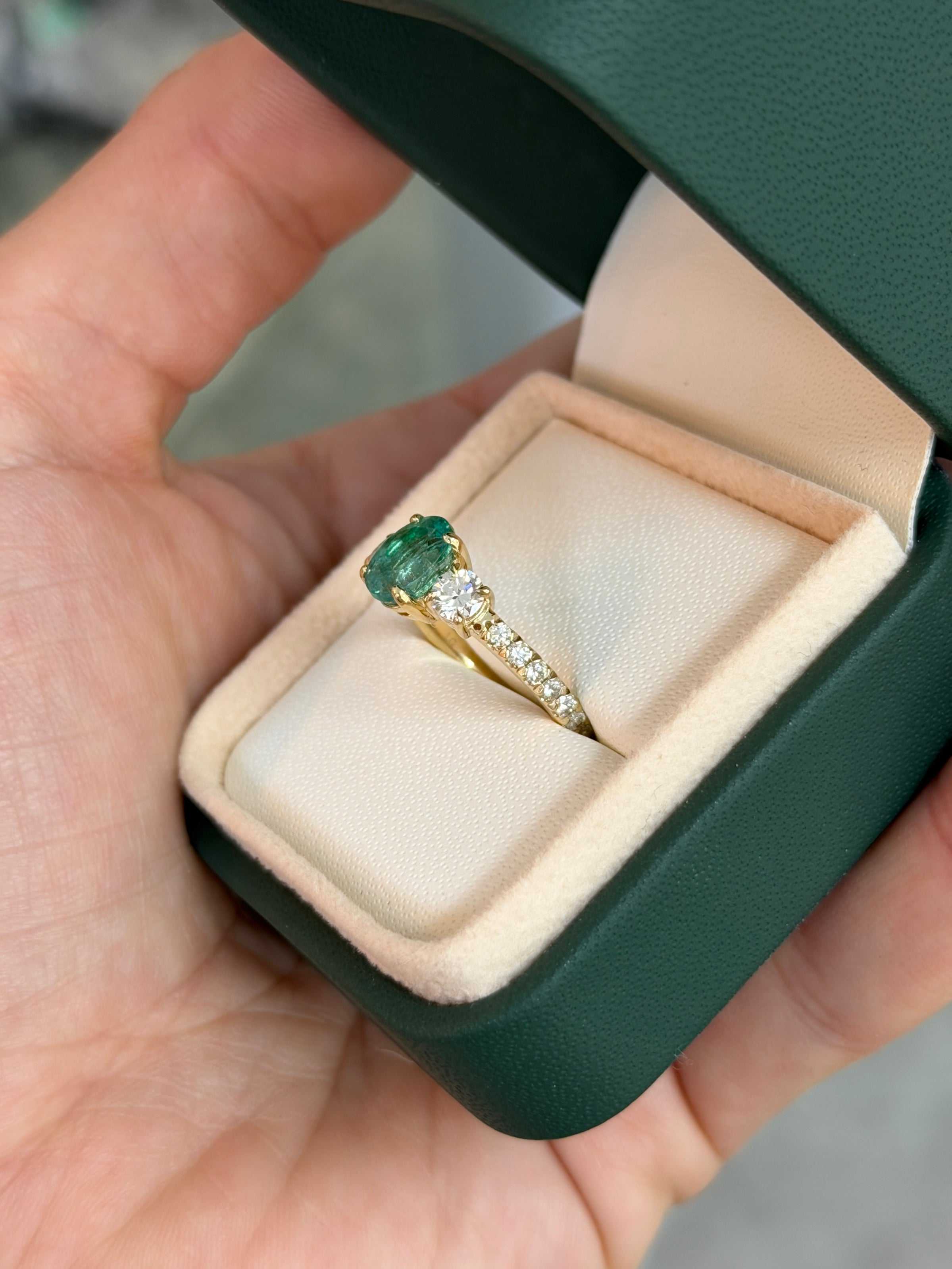 Two 2.40tcw oval emerald and round lab diamond three-stone ring with accent diamonds in 14K gold, featuring JR Colombian Emeralds branding.
