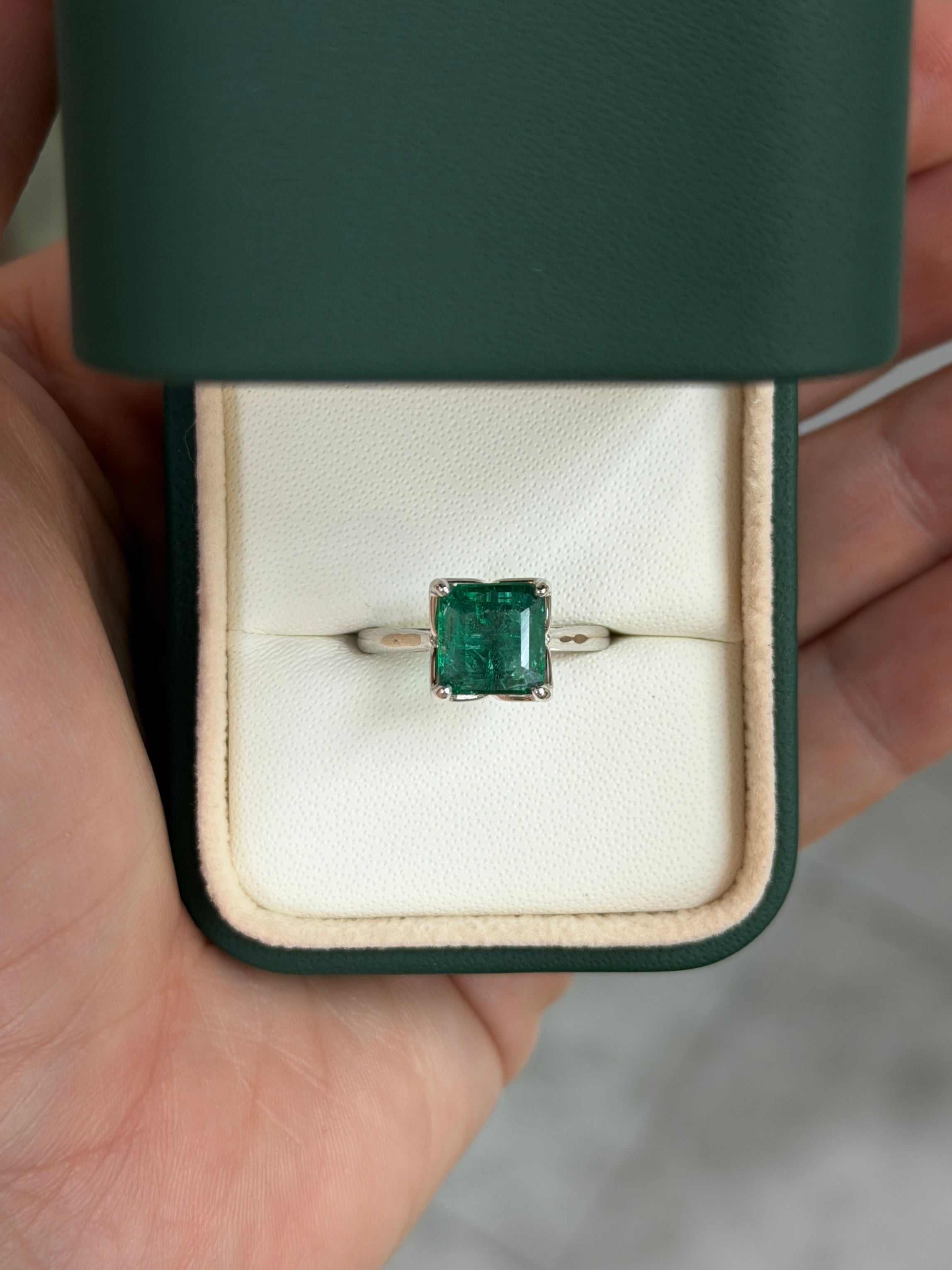 Asscher cut 2.93 carat natural emerald solitaire engagement ring in white gold, featuring a detailed view of the ring's setting and gemstone.