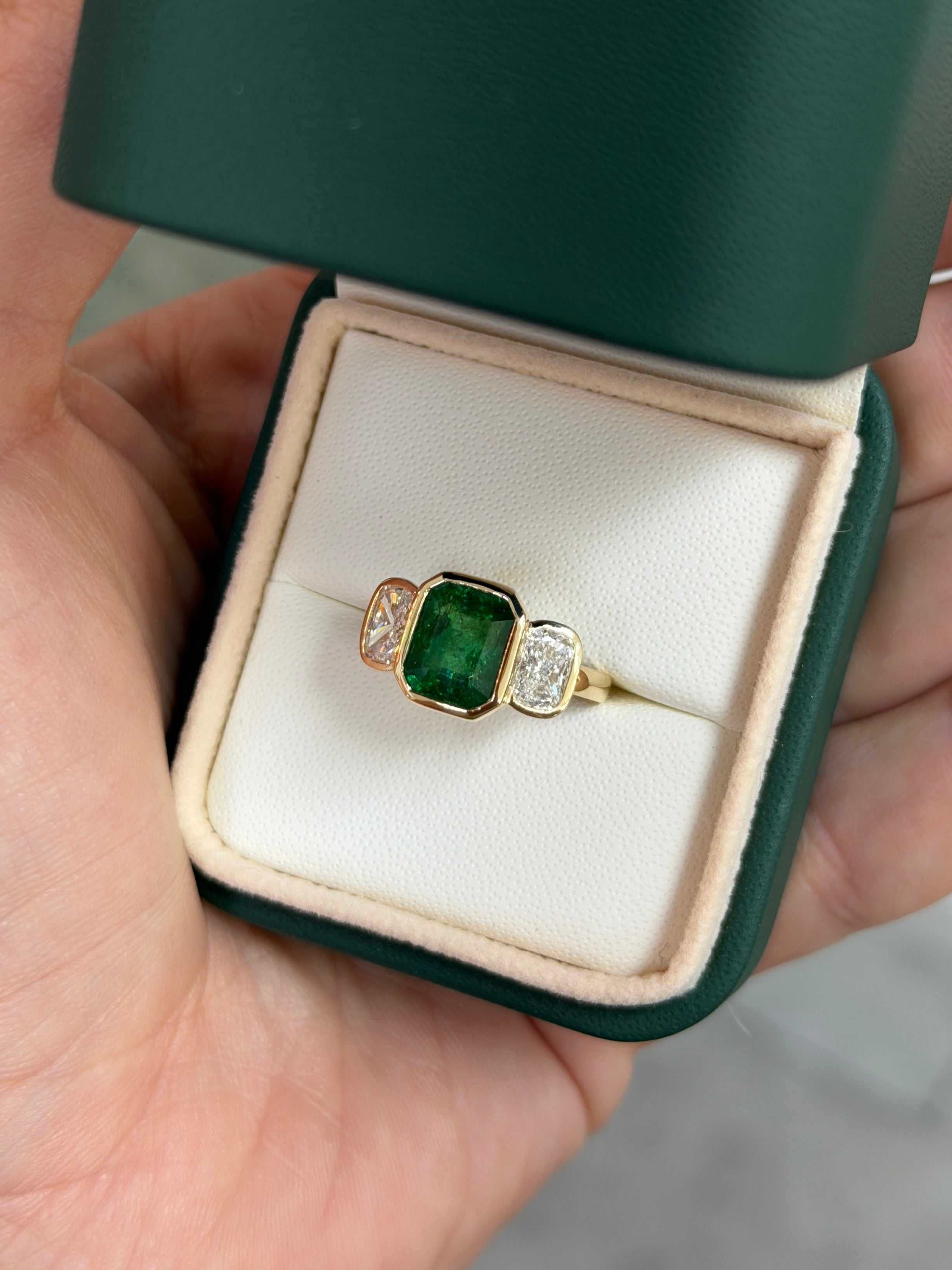JR Colombian Emeralds 3.70tcw bezel set emerald and cushion cut lab diamond three stone ring in 14K gold.