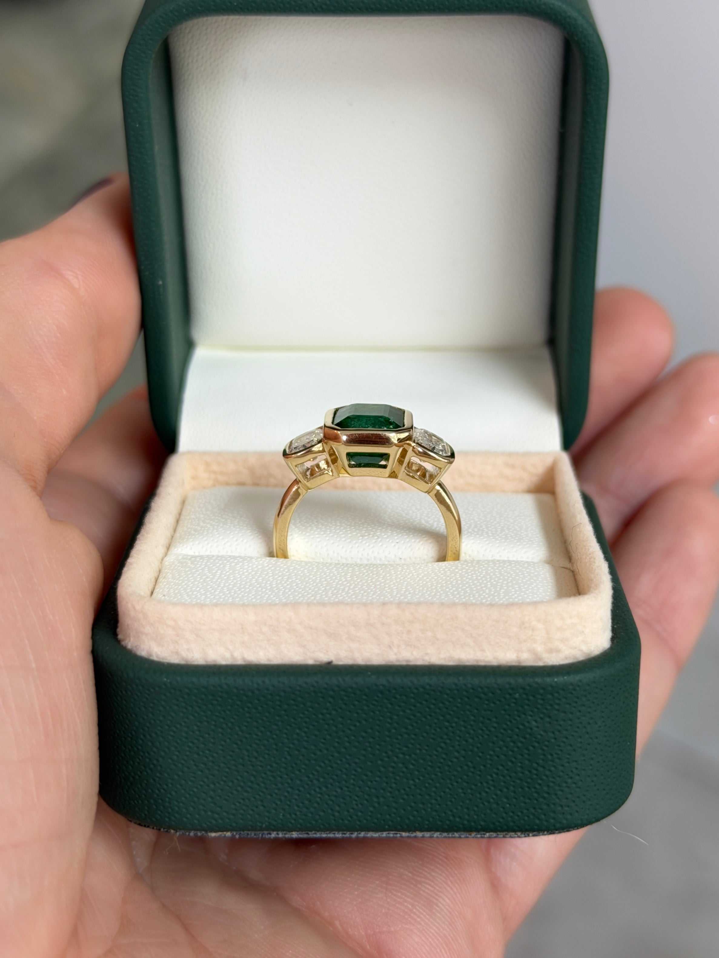 JR Colombian Emeralds 14K three stone ring featuring 3.70tcw bezel set emerald and cushion cut lab diamond in a stylish design.