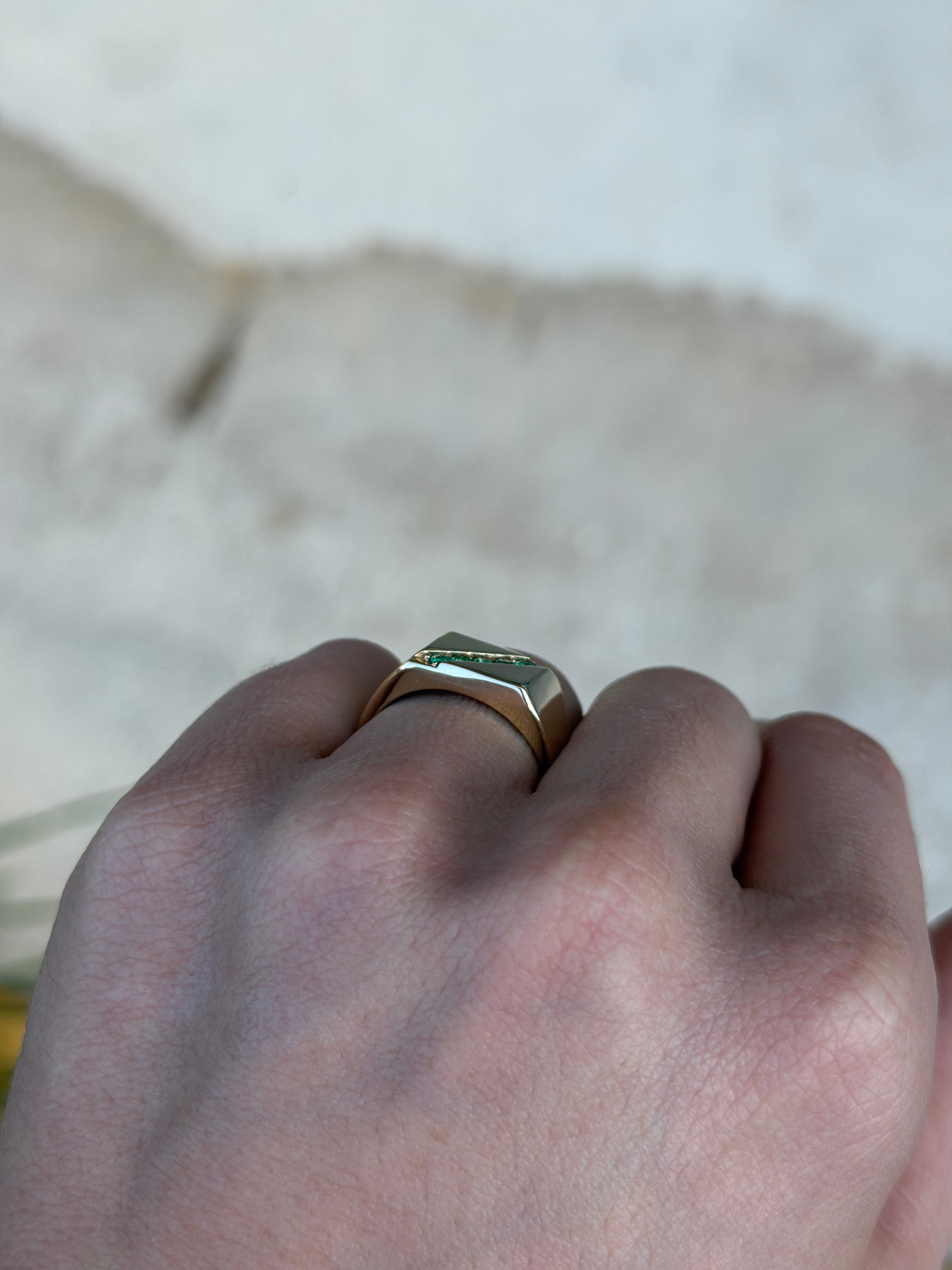14K gold men’s signet ring with round emeralds and channel setting, featuring 0.35tcw of vibrant Colombian emeralds.