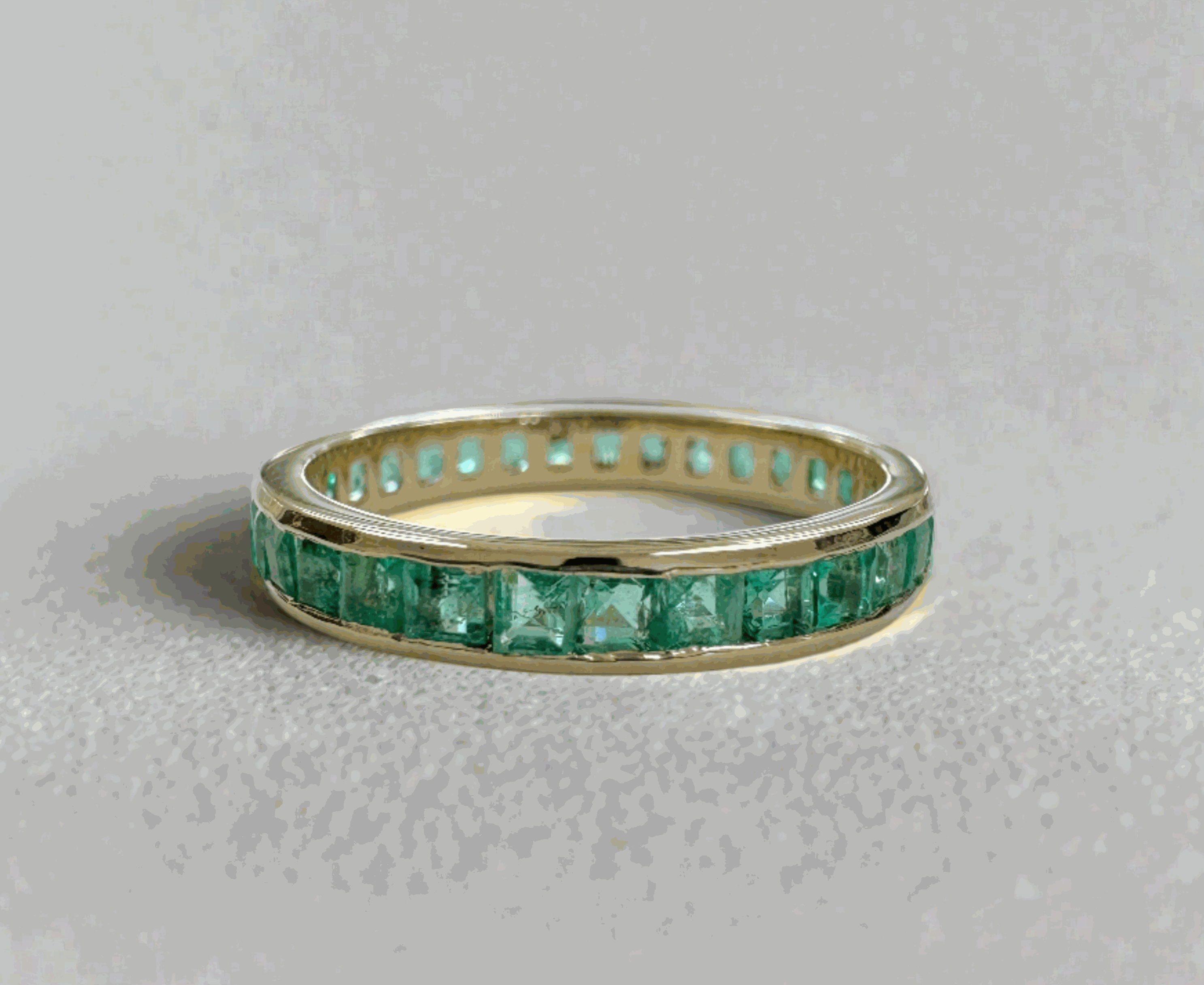 14K gold eternity band with princess cut emeralds totaling 1.44 carats, channel set in a JR Colombian Emeralds design.