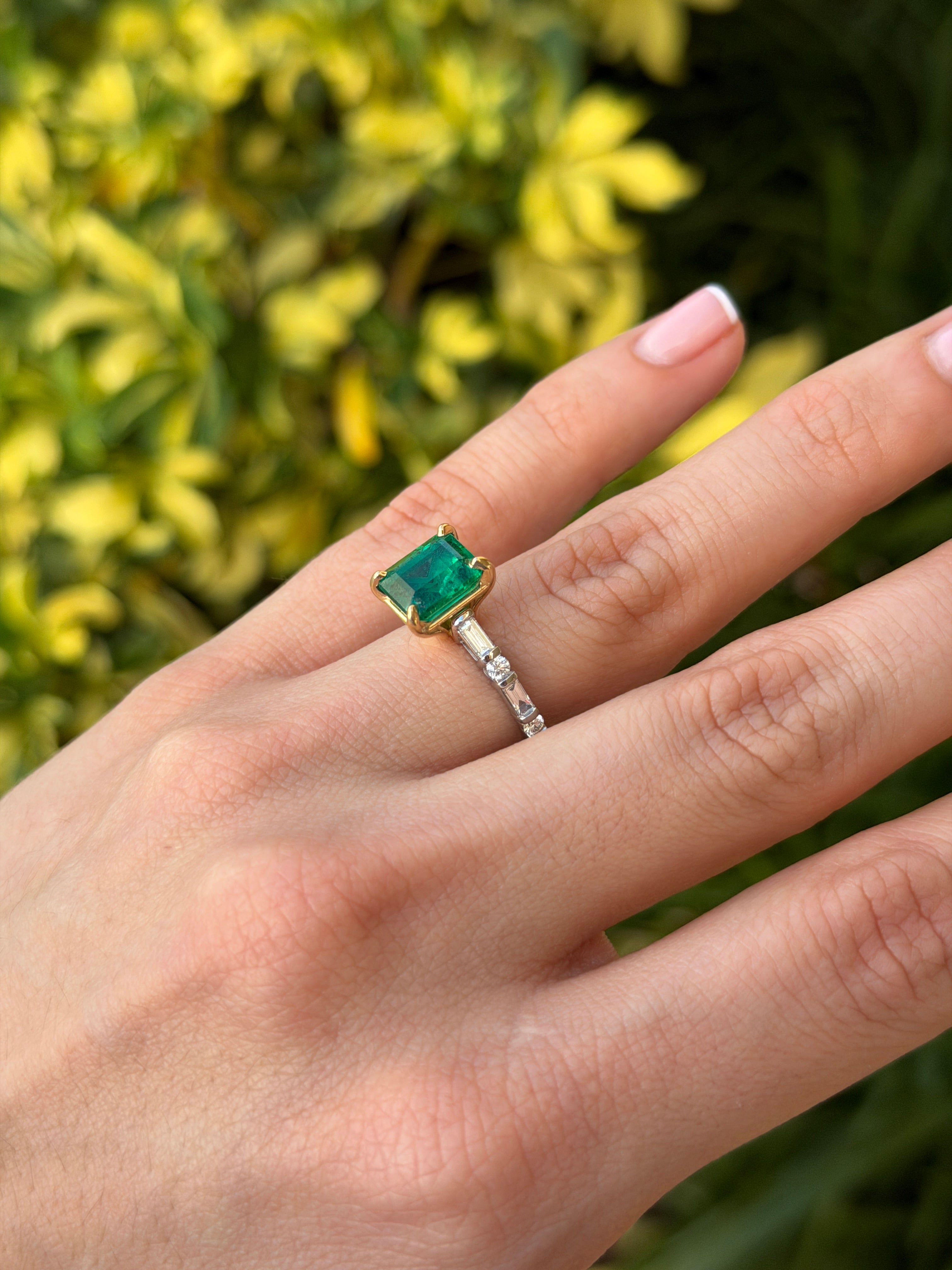 18K gold engagement ring with vivid natural emerald and platinum diamond baguette accents, featuring a 3.55tcw emerald center.
