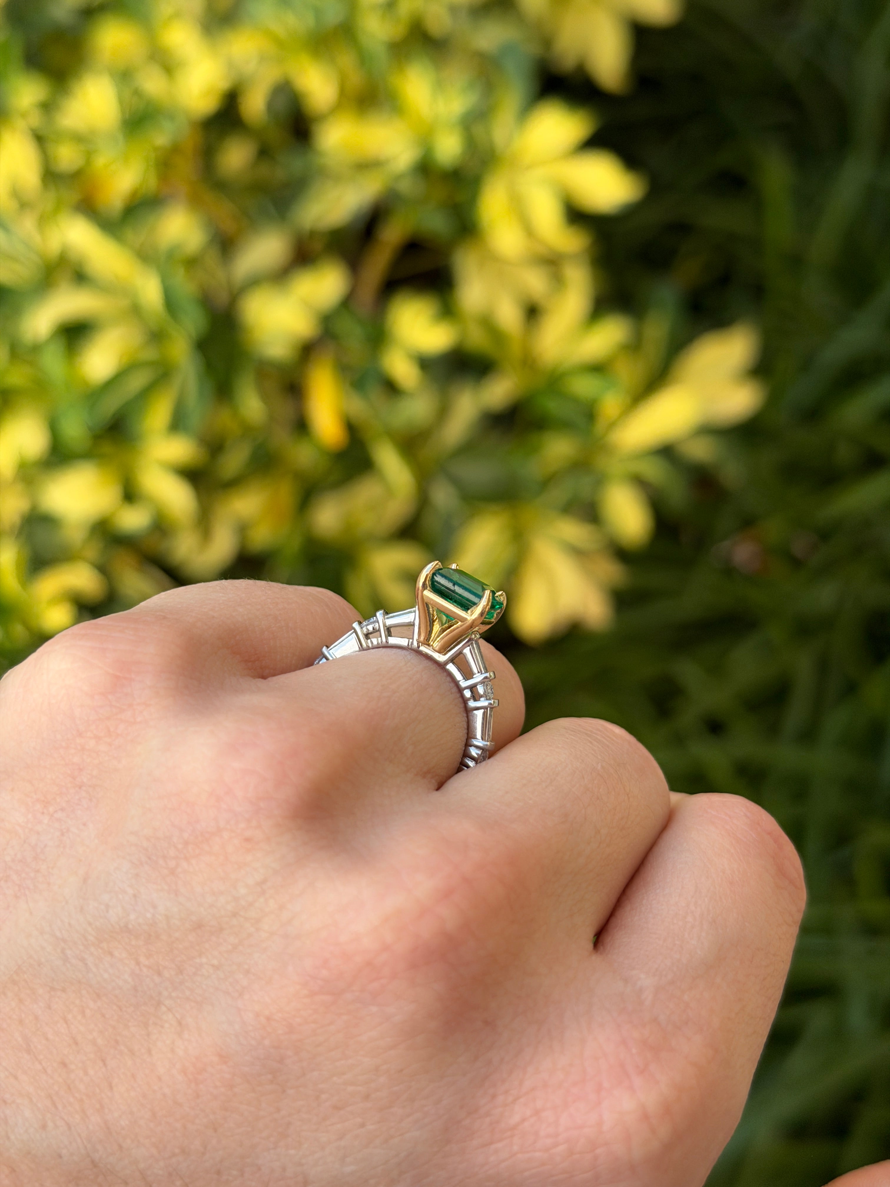 18K gold engagement ring with vivid natural emerald and platinum diamond baguette accents, featuring a 3.55ctw gemstone setting.