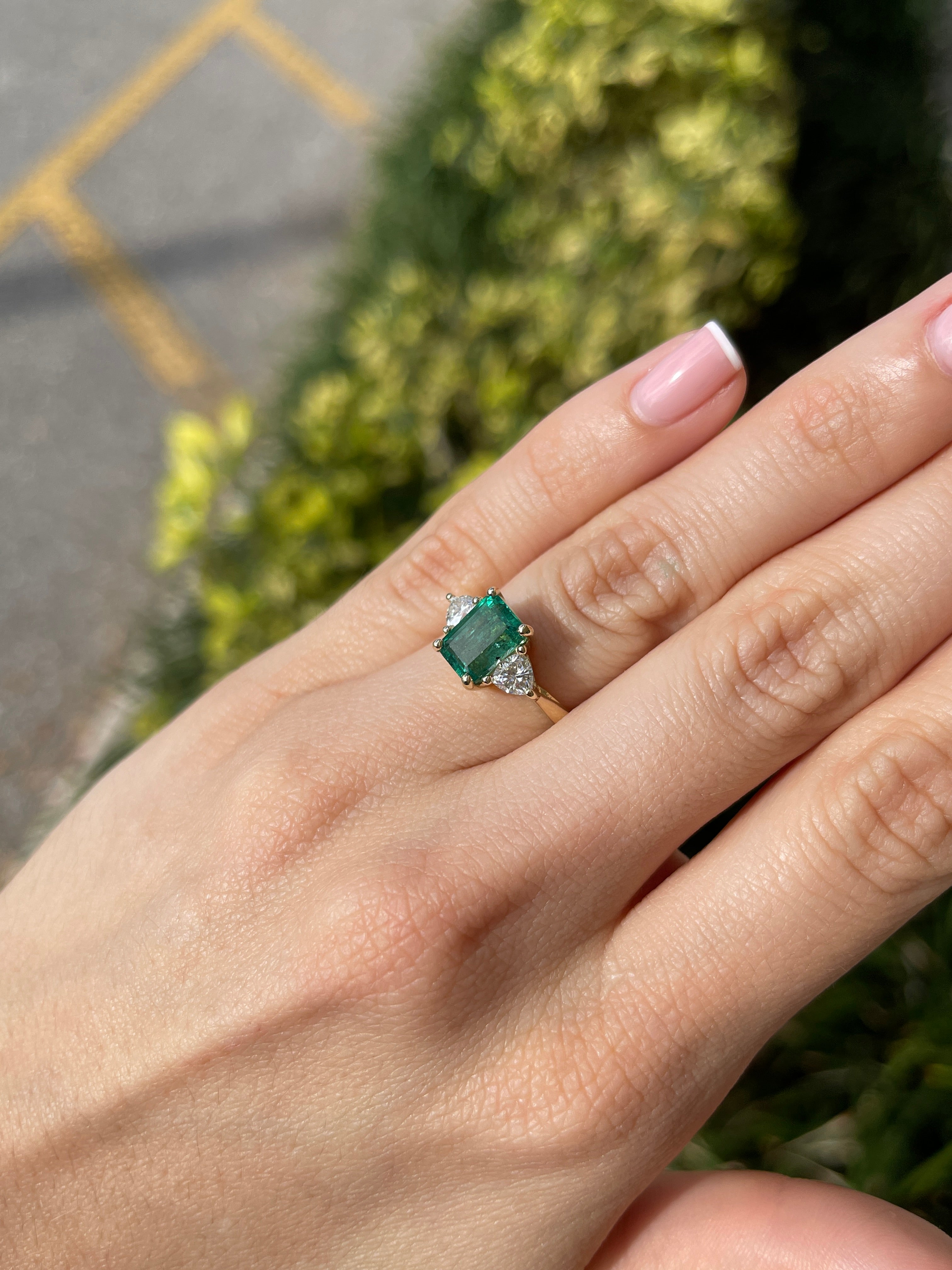 Natural emerald and lab diamond three-stone ring in 14K gold featuring trillion-cut stones, crafted by JR Colombian Emeralds.