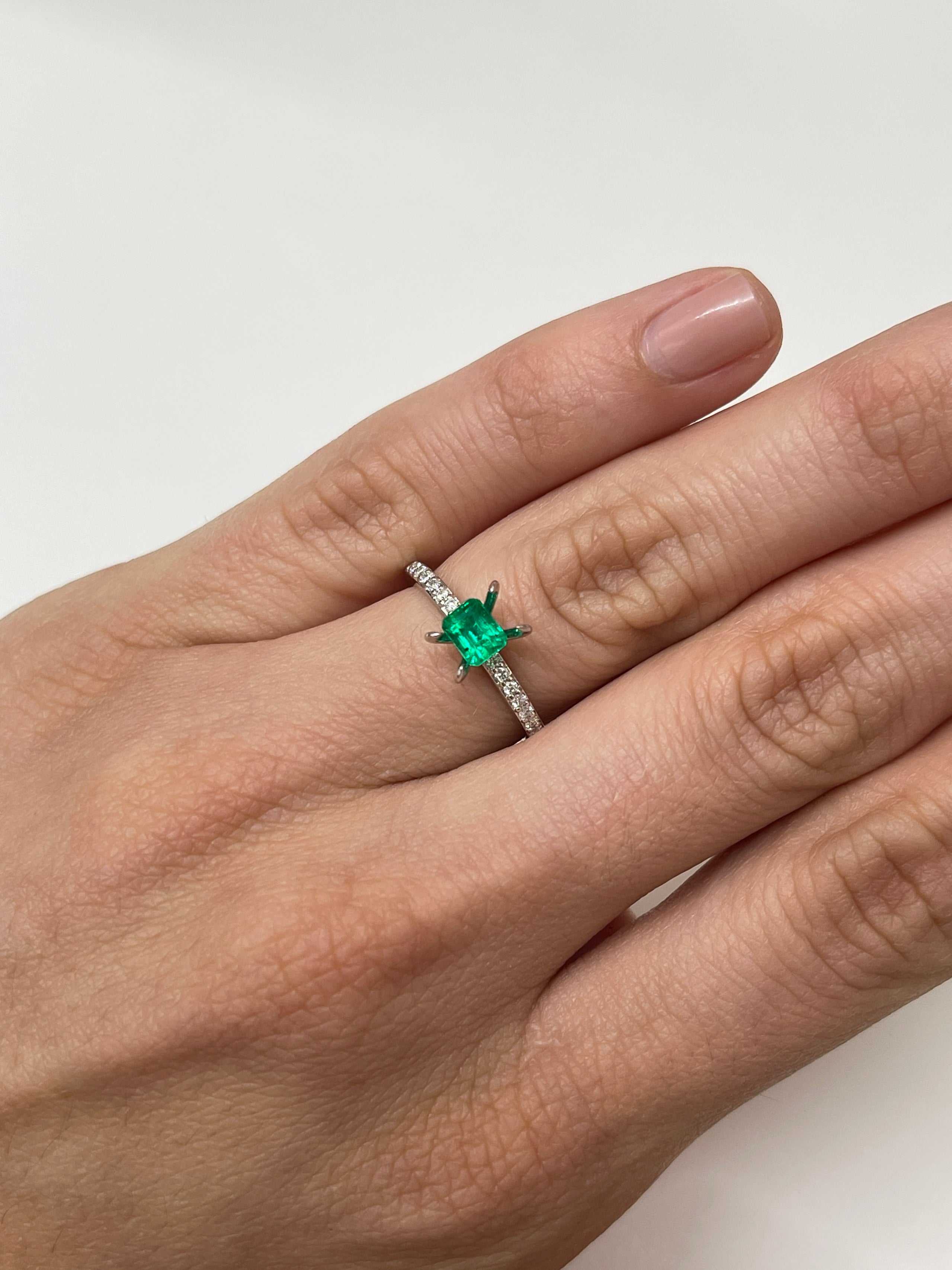 Loose 0.62 carat Colombian emerald in 5x4 mm emerald cut, AAA+ quality, displayed with a jewelry setting or background.