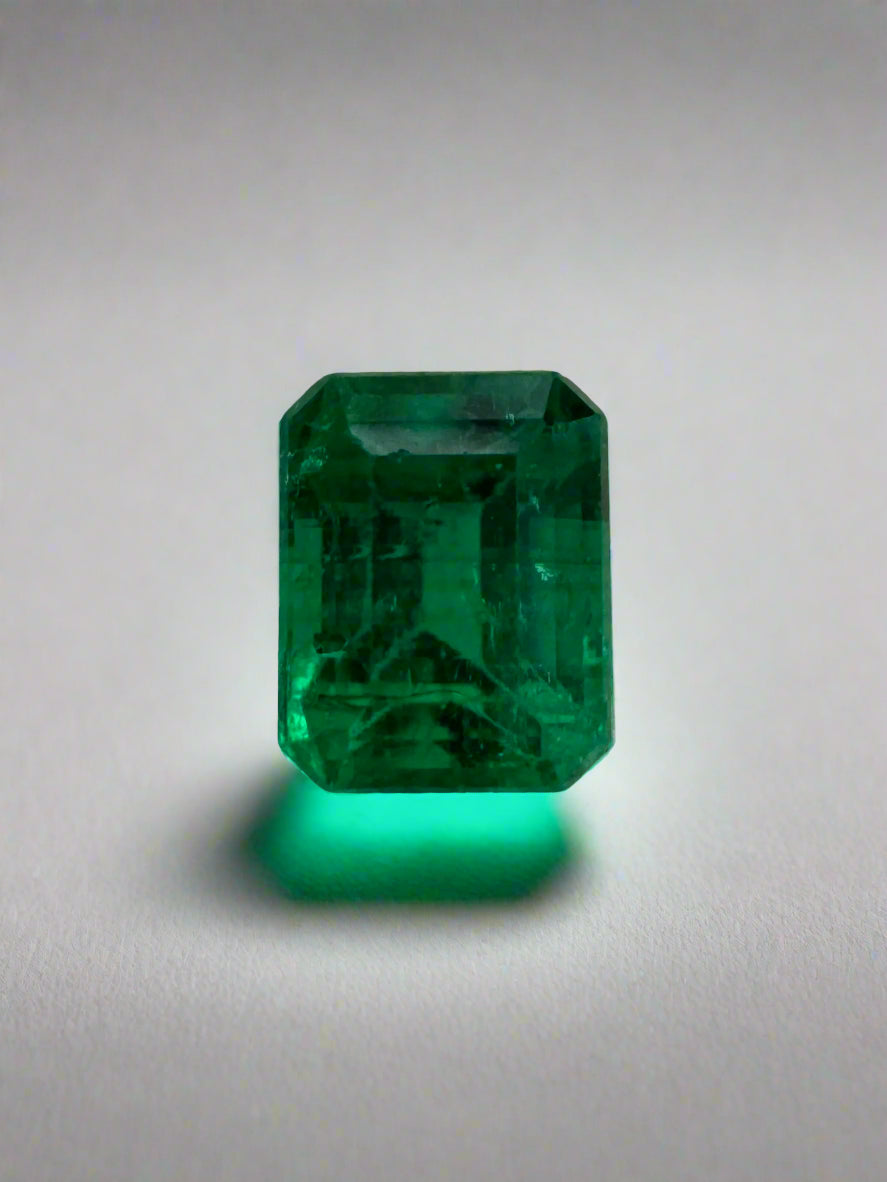 Loose 0.62 carat Colombian emerald cut gemstone with AAA+ clarity, showcasing vibrant green color and fine craftsmanship.