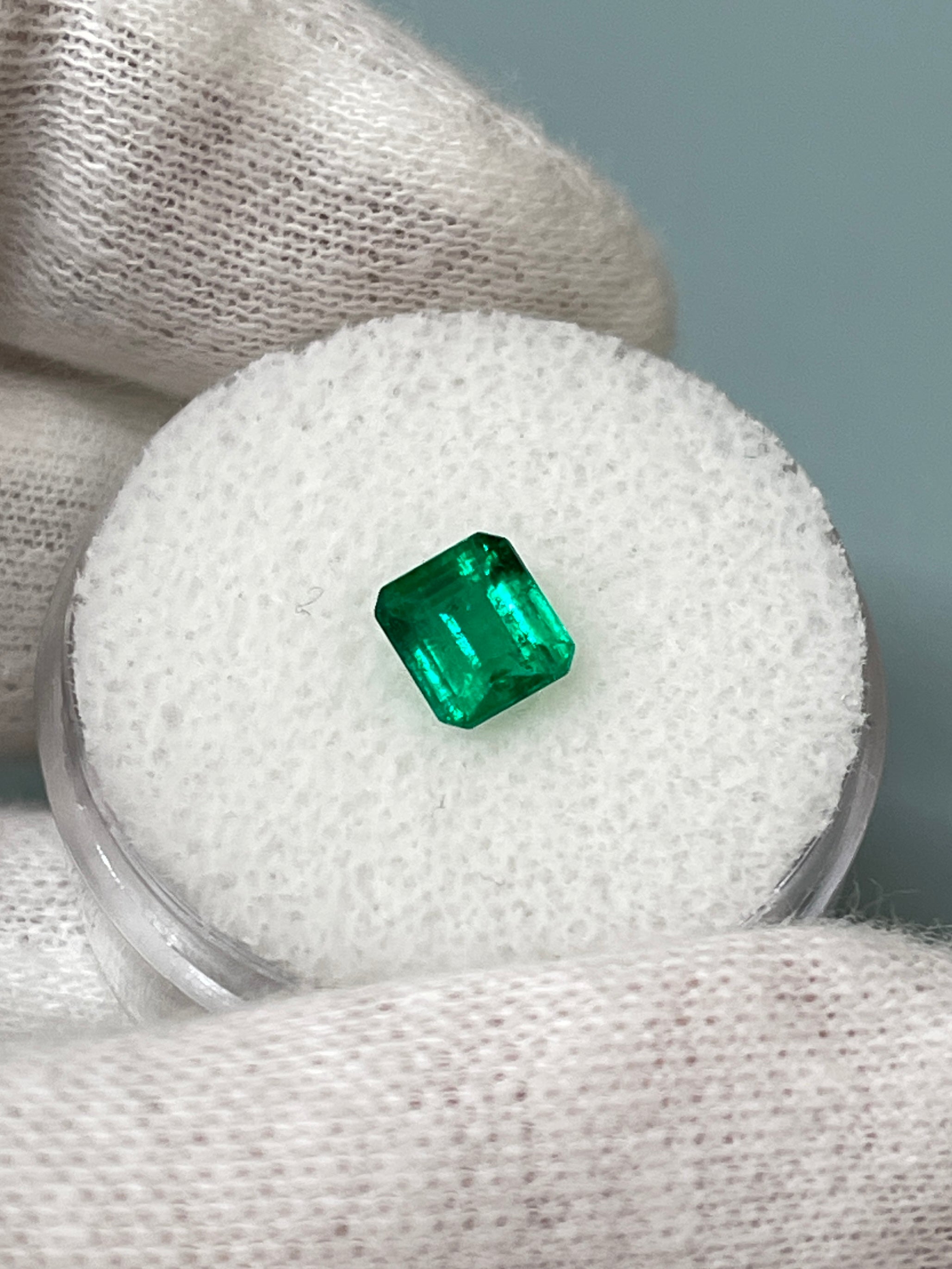 Loose 0.90 carat Colombian emerald in Asscher cut, showcasing vibrant green color, clarity, and fine AAA+ quality.